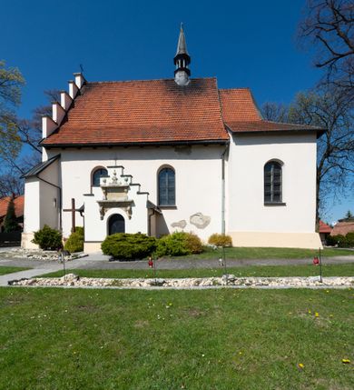 Zdjęcie nr 63: Kościół orientowany, murowany, jednonawowy z węższym prezbiterium zakończonym półkolistą absydą. Przy prezbiterium od północy znajduje się zakrystia, od południa kwadratowa kaplica św. Anny, a przy nawie od południa kruchta. Wnętrze kościoła nakryte jest nowym stropem, natomiast w kaplicy znajduje się sklepienie krzyżowo-żebrowe. Fasada zachodnia ujęta jest na narożnikach skośnymi szkarpami i zwieńczona schodkowym szczytem, podobnie zwieńczona jest kruchta południowa. Portal zachodni kamienny, z belkowaniem wspartym na dwóch liściastych konsolach ponad którymi edikula z płaskorzeźbionym krucyfiksem i klęczącymi postaciami męskimi. Na belkowaniu znajdują się dwa kartusze z herbami: po lewej herb Bończa, a nad nim litery „I” oraz „T”, a na prawo herb Szreniawa i litery „B” i „T”. Portal kruchty południowej jest również kamienny, podobny do zachodniego z inskrypcją: „IN LAVDEM ET GL[ORI]AM DEI O[MN]IP[OTENTIS] HO[NO]RE[M] / B(EATE) M(ARIAE) S(ANCTAE) V(IRGINIS) S(ANCTUS) AEGIDY ET OM(NIUM) SS. FIR. REGNÃTE [TERTIO] SIGISM[UN]DO / REGE POL[ONIAE] Z[?] HEMO[?] EP[ISCOP]O CRAC(OVIENSIS) BERN[AR]DO MACIEIOWSKI / NOVIT[ER] CAR[DINA]LI CRA[COVIENSE] DEI FACTO INTERI[M] PLEBA[N]O R[E]V[EREN]DO SEB(ASTIANO) / NAGRODIO A I SYRADIA PHI[LOSOPHI]AE DOCTORE COLLEG[I]A [MA]IORE / S. T(HEOLOGIAE) PVBLICO PROFES(SORE) PRAEP[OSI]TO S(ANCTA) AN(NAE) CRAC[OVIAE] DECIMARVM / ET FVNDI ECCL(ESIA)E HVIVS P[OST] IVRIS STREPITV(M) RESTITV / TORE ANNO OCTAVO PLEBANAT[U]S SVI. TEMPLVM HO(C) / [ dwa wiersze skute] DE&#039; / NOWO AEDIFICATVM. ET. CONSTRVCTVM. ADIVTORIO / QVORVNDÃ ANNO D[OMINI] MDCIIII MENSE SEPTEMB[RE]”. Od południa świątyni umieszczone są trzy otwory okienne w kształcie stojących prostokątów, zamkniętych łukiem półkolistym, a w prezbiterium dwa małe okrągłe okna. Kościół nakryty jest dwoma dwuspadowymi dachami, nad prezbiterium nieco niższym, nad nawą zwieńczonym wąską i wysoką sygnaturką na dzwon. Wewnątrz świątyni na skrzyżowaniu nawy i prezbiterium umocowana jest drewniana belka tęczowa z ustawionym na niej krucyfiksem i figurami Matki Boskiej i św. Jana Ewangelisty. Chór zachodni drewniany, na planie prostokąta, pośrodku półkoliście zamknięty, wsparty na sześciu filarach, od północnego zachodu z obudowaną boazerią klatką schodową. 