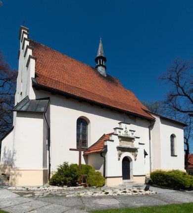 Zdjęcie nr 96: Kościół orientowany, murowany, jednonawowy z węższym prezbiterium zakończonym półkolistą absydą. Przy prezbiterium od północy znajduje się zakrystia, od południa kwadratowa kaplica św. Anny, a przy nawie od południa kruchta. Wnętrze kościoła nakryte jest nowym stropem, natomiast w kaplicy znajduje się sklepienie krzyżowo-żebrowe. Fasada zachodnia ujęta jest na narożnikach skośnymi szkarpami i zwieńczona schodkowym szczytem, podobnie zwieńczona jest kruchta południowa. Portal zachodni kamienny, z belkowaniem wspartym na dwóch liściastych konsolach ponad którymi edikula z płaskorzeźbionym krucyfiksem i klęczącymi postaciami męskimi. Na belkowaniu znajdują się dwa kartusze z herbami: po lewej herb Bończa, a nad nim litery „I” oraz „T”, a na prawo herb Szreniawa i litery „B” i „T”. Portal kruchty południowej jest również kamienny, podobny do zachodniego z inskrypcją: „IN LAVDEM ET GL[ORI]AM DEI O[MN]IP[OTENTIS] HO[NO]RE[M] / B(EATE) M(ARIAE) S(ANCTAE) V(IRGINIS) S(ANCTUS) AEGIDY ET OM(NIUM) SS. FIR. REGNÃTE [TERTIO] SIGISM[UN]DO / REGE POL[ONIAE] Z[?] HEMO[?] EP[ISCOP]O CRAC(OVIENSIS) BERN[AR]DO MACIEIOWSKI / NOVIT[ER] CAR[DINA]LI CRA[COVIENSE] DEI FACTO INTERI[M] PLEBA[N]O R[E]V[EREN]DO SEB(ASTIANO) / NAGRODIO A I SYRADIA PHI[LOSOPHI]AE DOCTORE COLLEG[I]A [MA]IORE / S. T(HEOLOGIAE) PVBLICO PROFES(SORE) PRAEP[OSI]TO S(ANCTA) AN(NAE) CRAC[OVIAE] DECIMARVM / ET FVNDI ECCL(ESIA)E HVIVS P[OST] IVRIS STREPITV(M) RESTITV / TORE ANNO OCTAVO PLEBANAT[U]S SVI. TEMPLVM HO(C) / [ dwa wiersze skute] DE' / NOWO AEDIFICATVM. ET. CONSTRVCTVM. ADIVTORIO / QVORVNDÃ ANNO D[OMINI] MDCIIII MENSE SEPTEMB[RE]”. Od południa świątyni umieszczone są trzy otwory okienne w kształcie stojących prostokątów, zamkniętych łukiem półkolistym, a w prezbiterium dwa małe okrągłe okna. Kościół nakryty jest dwoma dwuspadowymi dachami, nad prezbiterium nieco niższym, nad nawą zwieńczonym wąską i wysoką sygnaturką na dzwon. Wewnątrz świątyni na skrzyżowaniu nawy i prezbiterium umocowana jest drewniana belka tęczowa z ustawionym na niej krucyfiksem i figurami Matki Boskiej i św. Jana Ewangelisty. Chór zachodni drewniany, na planie prostokąta, pośrodku półkoliście zamknięty, wsparty na sześciu filarach, od północnego zachodu z obudowaną boazerią klatką schodową. 