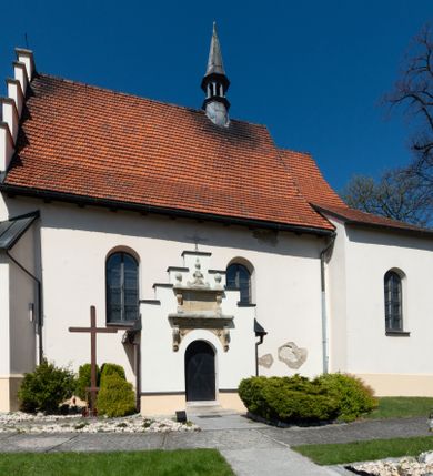 Zdjęcie nr 85: Kościół orientowany, murowany, jednonawowy z węższym prezbiterium zakończonym półkolistą absydą. Przy prezbiterium od północy znajduje się zakrystia, od południa kwadratowa kaplica św. Anny, a przy nawie od południa kruchta. Wnętrze kościoła nakryte jest nowym stropem, natomiast w kaplicy znajduje się sklepienie krzyżowo-żebrowe. Fasada zachodnia ujęta jest na narożnikach skośnymi szkarpami i zwieńczona schodkowym szczytem, podobnie zwieńczona jest kruchta południowa. Portal zachodni kamienny, z belkowaniem wspartym na dwóch liściastych konsolach ponad którymi edikula z płaskorzeźbionym krucyfiksem i klęczącymi postaciami męskimi. Na belkowaniu znajdują się dwa kartusze z herbami: po lewej herb Bończa, a nad nim litery „I” oraz „T”, a na prawo herb Szreniawa i litery „B” i „T”. Portal kruchty południowej jest również kamienny, podobny do zachodniego z inskrypcją: „IN LAVDEM ET GL[ORI]AM DEI O[MN]IP[OTENTIS] HO[NO]RE[M] / B(EATE) M(ARIAE) S(ANCTAE) V(IRGINIS) S(ANCTUS) AEGIDY ET OM(NIUM) SS. FIR. REGNÃTE [TERTIO] SIGISM[UN]DO / REGE POL[ONIAE] Z[?] HEMO[?] EP[ISCOP]O CRAC(OVIENSIS) BERN[AR]DO MACIEIOWSKI / NOVIT[ER] CAR[DINA]LI CRA[COVIENSE] DEI FACTO INTERI[M] PLEBA[N]O R[E]V[EREN]DO SEB(ASTIANO) / NAGRODIO A I SYRADIA PHI[LOSOPHI]AE DOCTORE COLLEG[I]A [MA]IORE / S. T(HEOLOGIAE) PVBLICO PROFES(SORE) PRAEP[OSI]TO S(ANCTA) AN(NAE) CRAC[OVIAE] DECIMARVM / ET FVNDI ECCL(ESIA)E HVIVS P[OST] IVRIS STREPITV(M) RESTITV / TORE ANNO OCTAVO PLEBANAT[U]S SVI. TEMPLVM HO(C) / [ dwa wiersze skute] DE' / NOWO AEDIFICATVM. ET. CONSTRVCTVM. ADIVTORIO / QVORVNDÃ ANNO D[OMINI] MDCIIII MENSE SEPTEMB[RE]”. Od południa świątyni umieszczone są trzy otwory okienne w kształcie stojących prostokątów, zamkniętych łukiem półkolistym, a w prezbiterium dwa małe okrągłe okna. Kościół nakryty jest dwoma dwuspadowymi dachami, nad prezbiterium nieco niższym, nad nawą zwieńczonym wąską i wysoką sygnaturką na dzwon. Wewnątrz świątyni na skrzyżowaniu nawy i prezbiterium umocowana jest drewniana belka tęczowa z ustawionym na niej krucyfiksem i figurami Matki Boskiej i św. Jana Ewangelisty. Chór zachodni drewniany, na planie prostokąta, pośrodku półkoliście zamknięty, wsparty na sześciu filarach, od północnego zachodu z obudowaną boazerią klatką schodową. 