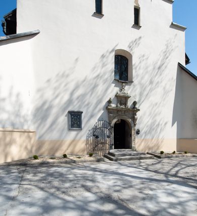 Zdjęcie nr 13: Kościół orientowany, murowany, jednonawowy z węższym prezbiterium zakończonym półkolistą absydą. Przy prezbiterium od północy znajduje się zakrystia, od południa kwadratowa kaplica św. Anny, a przy nawie od południa kruchta. Wnętrze kościoła nakryte jest nowym stropem, natomiast w kaplicy znajduje się sklepienie krzyżowo-żebrowe. Fasada zachodnia ujęta jest na narożnikach skośnymi szkarpami i zwieńczona schodkowym szczytem, podobnie zwieńczona jest kruchta południowa. Portal zachodni kamienny, z belkowaniem wspartym na dwóch liściastych konsolach ponad którymi edikula z płaskorzeźbionym krucyfiksem i klęczącymi postaciami męskimi. Na belkowaniu znajdują się dwa kartusze z herbami: po lewej herb Bończa, a nad nim litery „I” oraz „T”, a na prawo herb Szreniawa i litery „B” i „T”. Portal kruchty południowej jest również kamienny, podobny do zachodniego z inskrypcją: „IN LAVDEM ET GL[ORI]AM DEI O[MN]IP[OTENTIS] HO[NO]RE[M] / B(EATE) M(ARIAE) S(ANCTAE) V(IRGINIS) S(ANCTUS) AEGIDY ET OM(NIUM) SS. FIR. REGNÃTE [TERTIO] SIGISM[UN]DO / REGE POL[ONIAE] Z[?] HEMO[?] EP[ISCOP]O CRAC(OVIENSIS) BERN[AR]DO MACIEIOWSKI / NOVIT[ER] CAR[DINA]LI CRA[COVIENSE] DEI FACTO INTERI[M] PLEBA[N]O R[E]V[EREN]DO SEB(ASTIANO) / NAGRODIO A I SYRADIA PHI[LOSOPHI]AE DOCTORE COLLEG[I]A [MA]IORE / S. T(HEOLOGIAE) PVBLICO PROFES(SORE) PRAEP[OSI]TO S(ANCTA) AN(NAE) CRAC[OVIAE] DECIMARVM / ET FVNDI ECCL(ESIA)E HVIVS P[OST] IVRIS STREPITV(M) RESTITV / TORE ANNO OCTAVO PLEBANAT[U]S SVI. TEMPLVM HO(C) / [ dwa wiersze skute] DE' / NOWO AEDIFICATVM. ET. CONSTRVCTVM. ADIVTORIO / QVORVNDÃ ANNO D[OMINI] MDCIIII MENSE SEPTEMB[RE]”. Od południa świątyni umieszczone są trzy otwory okienne w kształcie stojących prostokątów, zamkniętych łukiem półkolistym, a w prezbiterium dwa małe okrągłe okna. Kościół nakryty jest dwoma dwuspadowymi dachami, nad prezbiterium nieco niższym, nad nawą zwieńczonym wąską i wysoką sygnaturką na dzwon. Wewnątrz świątyni na skrzyżowaniu nawy i prezbiterium umocowana jest drewniana belka tęczowa z ustawionym na niej krucyfiksem i figurami Matki Boskiej i św. Jana Ewangelisty. Chór zachodni drewniany, na planie prostokąta, pośrodku półkoliście zamknięty, wsparty na sześciu filarach, od północnego zachodu z obudowaną boazerią klatką schodową. 