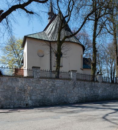 Zdjęcie nr 25: Kościół orientowany, murowany, jednonawowy z węższym prezbiterium zakończonym półkolistą absydą. Przy prezbiterium od północy znajduje się zakrystia, od południa kwadratowa kaplica św. Anny, a przy nawie od południa kruchta. Wnętrze kościoła nakryte jest nowym stropem, natomiast w kaplicy znajduje się sklepienie krzyżowo-żebrowe. Fasada zachodnia ujęta jest na narożnikach skośnymi szkarpami i zwieńczona schodkowym szczytem, podobnie zwieńczona jest kruchta południowa. Portal zachodni kamienny, z belkowaniem wspartym na dwóch liściastych konsolach ponad którymi edikula z płaskorzeźbionym krucyfiksem i klęczącymi postaciami męskimi. Na belkowaniu znajdują się dwa kartusze z herbami: po lewej herb Bończa, a nad nim litery „I” oraz „T”, a na prawo herb Szreniawa i litery „B” i „T”. Portal kruchty południowej jest również kamienny, podobny do zachodniego z inskrypcją: „IN LAVDEM ET GL[ORI]AM DEI O[MN]IP[OTENTIS] HO[NO]RE[M] / B(EATE) M(ARIAE) S(ANCTAE) V(IRGINIS) S(ANCTUS) AEGIDY ET OM(NIUM) SS. FIR. REGNÃTE [TERTIO] SIGISM[UN]DO / REGE POL[ONIAE] Z[?] HEMO[?] EP[ISCOP]O CRAC(OVIENSIS) BERN[AR]DO MACIEIOWSKI / NOVIT[ER] CAR[DINA]LI CRA[COVIENSE] DEI FACTO INTERI[M] PLEBA[N]O R[E]V[EREN]DO SEB(ASTIANO) / NAGRODIO A I SYRADIA PHI[LOSOPHI]AE DOCTORE COLLEG[I]A [MA]IORE / S. T(HEOLOGIAE) PVBLICO PROFES(SORE) PRAEP[OSI]TO S(ANCTA) AN(NAE) CRAC[OVIAE] DECIMARVM / ET FVNDI ECCL(ESIA)E HVIVS P[OST] IVRIS STREPITV(M) RESTITV / TORE ANNO OCTAVO PLEBANAT[U]S SVI. TEMPLVM HO(C) / [ dwa wiersze skute] DE' / NOWO AEDIFICATVM. ET. CONSTRVCTVM. ADIVTORIO / QVORVNDÃ ANNO D[OMINI] MDCIIII MENSE SEPTEMB[RE]”. Od południa świątyni umieszczone są trzy otwory okienne w kształcie stojących prostokątów, zamkniętych łukiem półkolistym, a w prezbiterium dwa małe okrągłe okna. Kościół nakryty jest dwoma dwuspadowymi dachami, nad prezbiterium nieco niższym, nad nawą zwieńczonym wąską i wysoką sygnaturką na dzwon. Wewnątrz świątyni na skrzyżowaniu nawy i prezbiterium umocowana jest drewniana belka tęczowa z ustawionym na niej krucyfiksem i figurami Matki Boskiej i św. Jana Ewangelisty. Chór zachodni drewniany, na planie prostokąta, pośrodku półkoliście zamknięty, wsparty na sześciu filarach, od północnego zachodu z obudowaną boazerią klatką schodową. 