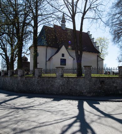 Zdjęcie nr 15: Kościół orientowany, murowany, jednonawowy z węższym prezbiterium zakończonym półkolistą absydą. Przy prezbiterium od północy znajduje się zakrystia, od południa kwadratowa kaplica św. Anny, a przy nawie od południa kruchta. Wnętrze kościoła nakryte jest nowym stropem, natomiast w kaplicy znajduje się sklepienie krzyżowo-żebrowe. Fasada zachodnia ujęta jest na narożnikach skośnymi szkarpami i zwieńczona schodkowym szczytem, podobnie zwieńczona jest kruchta południowa. Portal zachodni kamienny, z belkowaniem wspartym na dwóch liściastych konsolach ponad którymi edikula z płaskorzeźbionym krucyfiksem i klęczącymi postaciami męskimi. Na belkowaniu znajdują się dwa kartusze z herbami: po lewej herb Bończa, a nad nim litery „I” oraz „T”, a na prawo herb Szreniawa i litery „B” i „T”. Portal kruchty południowej jest również kamienny, podobny do zachodniego z inskrypcją: „IN LAVDEM ET GL[ORI]AM DEI O[MN]IP[OTENTIS] HO[NO]RE[M] / B(EATE) M(ARIAE) S(ANCTAE) V(IRGINIS) S(ANCTUS) AEGIDY ET OM(NIUM) SS. FIR. REGNÃTE [TERTIO] SIGISM[UN]DO / REGE POL[ONIAE] Z[?] HEMO[?] EP[ISCOP]O CRAC(OVIENSIS) BERN[AR]DO MACIEIOWSKI / NOVIT[ER] CAR[DINA]LI CRA[COVIENSE] DEI FACTO INTERI[M] PLEBA[N]O R[E]V[EREN]DO SEB(ASTIANO) / NAGRODIO A I SYRADIA PHI[LOSOPHI]AE DOCTORE COLLEG[I]A [MA]IORE / S. T(HEOLOGIAE) PVBLICO PROFES(SORE) PRAEP[OSI]TO S(ANCTA) AN(NAE) CRAC[OVIAE] DECIMARVM / ET FVNDI ECCL(ESIA)E HVIVS P[OST] IVRIS STREPITV(M) RESTITV / TORE ANNO OCTAVO PLEBANAT[U]S SVI. TEMPLVM HO(C) / [ dwa wiersze skute] DE' / NOWO AEDIFICATVM. ET. CONSTRVCTVM. ADIVTORIO / QVORVNDÃ ANNO D[OMINI] MDCIIII MENSE SEPTEMB[RE]”. Od południa świątyni umieszczone są trzy otwory okienne w kształcie stojących prostokątów, zamkniętych łukiem półkolistym, a w prezbiterium dwa małe okrągłe okna. Kościół nakryty jest dwoma dwuspadowymi dachami, nad prezbiterium nieco niższym, nad nawą zwieńczonym wąską i wysoką sygnaturką na dzwon. Wewnątrz świątyni na skrzyżowaniu nawy i prezbiterium umocowana jest drewniana belka tęczowa z ustawionym na niej krucyfiksem i figurami Matki Boskiej i św. Jana Ewangelisty. Chór zachodni drewniany, na planie prostokąta, pośrodku półkoliście zamknięty, wsparty na sześciu filarach, od północnego zachodu z obudowaną boazerią klatką schodową. 