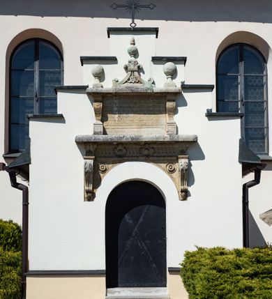 Zdjęcie nr 39: Kościół orientowany, murowany, jednonawowy z węższym prezbiterium zakończonym półkolistą absydą. Przy prezbiterium od północy znajduje się zakrystia, od południa kwadratowa kaplica św. Anny, a przy nawie od południa kruchta. Wnętrze kościoła nakryte jest nowym stropem, natomiast w kaplicy znajduje się sklepienie krzyżowo-żebrowe. Fasada zachodnia ujęta jest na narożnikach skośnymi szkarpami i zwieńczona schodkowym szczytem, podobnie zwieńczona jest kruchta południowa. Portal zachodni kamienny, z belkowaniem wspartym na dwóch liściastych konsolach ponad którymi edikula z płaskorzeźbionym krucyfiksem i klęczącymi postaciami męskimi. Na belkowaniu znajdują się dwa kartusze z herbami: po lewej herb Bończa, a nad nim litery „I” oraz „T”, a na prawo herb Szreniawa i litery „B” i „T”. Portal kruchty południowej jest również kamienny, podobny do zachodniego z inskrypcją: „IN LAVDEM ET GL[ORI]AM DEI O[MN]IP[OTENTIS] HO[NO]RE[M] / B(EATE) M(ARIAE) S(ANCTAE) V(IRGINIS) S(ANCTUS) AEGIDY ET OM(NIUM) SS. FIR. REGNÃTE [TERTIO] SIGISM[UN]DO / REGE POL[ONIAE] Z[?] HEMO[?] EP[ISCOP]O CRAC(OVIENSIS) BERN[AR]DO MACIEIOWSKI / NOVIT[ER] CAR[DINA]LI CRA[COVIENSE] DEI FACTO INTERI[M] PLEBA[N]O R[E]V[EREN]DO SEB(ASTIANO) / NAGRODIO A I SYRADIA PHI[LOSOPHI]AE DOCTORE COLLEG[I]A [MA]IORE / S. T(HEOLOGIAE) PVBLICO PROFES(SORE) PRAEP[OSI]TO S(ANCTA) AN(NAE) CRAC[OVIAE] DECIMARVM / ET FVNDI ECCL(ESIA)E HVIVS P[OST] IVRIS STREPITV(M) RESTITV / TORE ANNO OCTAVO PLEBANAT[U]S SVI. TEMPLVM HO(C) / [ dwa wiersze skute] DE' / NOWO AEDIFICATVM. ET. CONSTRVCTVM. ADIVTORIO / QVORVNDÃ ANNO D[OMINI] MDCIIII MENSE SEPTEMB[RE]”. Od południa świątyni umieszczone są trzy otwory okienne w kształcie stojących prostokątów, zamkniętych łukiem półkolistym, a w prezbiterium dwa małe okrągłe okna. Kościół nakryty jest dwoma dwuspadowymi dachami, nad prezbiterium nieco niższym, nad nawą zwieńczonym wąską i wysoką sygnaturką na dzwon. Wewnątrz świątyni na skrzyżowaniu nawy i prezbiterium umocowana jest drewniana belka tęczowa z ustawionym na niej krucyfiksem i figurami Matki Boskiej i św. Jana Ewangelisty. Chór zachodni drewniany, na planie prostokąta, pośrodku półkoliście zamknięty, wsparty na sześciu filarach, od północnego zachodu z obudowaną boazerią klatką schodową. 