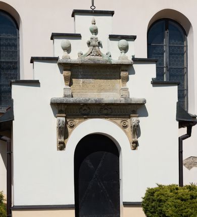 Zdjęcie nr 40: Kościół orientowany, murowany, jednonawowy z węższym prezbiterium zakończonym półkolistą absydą. Przy prezbiterium od północy znajduje się zakrystia, od południa kwadratowa kaplica św. Anny, a przy nawie od południa kruchta. Wnętrze kościoła nakryte jest nowym stropem, natomiast w kaplicy znajduje się sklepienie krzyżowo-żebrowe. Fasada zachodnia ujęta jest na narożnikach skośnymi szkarpami i zwieńczona schodkowym szczytem, podobnie zwieńczona jest kruchta południowa. Portal zachodni kamienny, z belkowaniem wspartym na dwóch liściastych konsolach ponad którymi edikula z płaskorzeźbionym krucyfiksem i klęczącymi postaciami męskimi. Na belkowaniu znajdują się dwa kartusze z herbami: po lewej herb Bończa, a nad nim litery „I” oraz „T”, a na prawo herb Szreniawa i litery „B” i „T”. Portal kruchty południowej jest również kamienny, podobny do zachodniego z inskrypcją: „IN LAVDEM ET GL[ORI]AM DEI O[MN]IP[OTENTIS] HO[NO]RE[M] / B(EATE) M(ARIAE) S(ANCTAE) V(IRGINIS) S(ANCTUS) AEGIDY ET OM(NIUM) SS. FIR. REGNÃTE [TERTIO] SIGISM[UN]DO / REGE POL[ONIAE] Z[?] HEMO[?] EP[ISCOP]O CRAC(OVIENSIS) BERN[AR]DO MACIEIOWSKI / NOVIT[ER] CAR[DINA]LI CRA[COVIENSE] DEI FACTO INTERI[M] PLEBA[N]O R[E]V[EREN]DO SEB(ASTIANO) / NAGRODIO A I SYRADIA PHI[LOSOPHI]AE DOCTORE COLLEG[I]A [MA]IORE / S. T(HEOLOGIAE) PVBLICO PROFES(SORE) PRAEP[OSI]TO S(ANCTA) AN(NAE) CRAC[OVIAE] DECIMARVM / ET FVNDI ECCL(ESIA)E HVIVS P[OST] IVRIS STREPITV(M) RESTITV / TORE ANNO OCTAVO PLEBANAT[U]S SVI. TEMPLVM HO(C) / [ dwa wiersze skute] DE' / NOWO AEDIFICATVM. ET. CONSTRVCTVM. ADIVTORIO / QVORVNDÃ ANNO D[OMINI] MDCIIII MENSE SEPTEMB[RE]”. Od południa świątyni umieszczone są trzy otwory okienne w kształcie stojących prostokątów, zamkniętych łukiem półkolistym, a w prezbiterium dwa małe okrągłe okna. Kościół nakryty jest dwoma dwuspadowymi dachami, nad prezbiterium nieco niższym, nad nawą zwieńczonym wąską i wysoką sygnaturką na dzwon. Wewnątrz świątyni na skrzyżowaniu nawy i prezbiterium umocowana jest drewniana belka tęczowa z ustawionym na niej krucyfiksem i figurami Matki Boskiej i św. Jana Ewangelisty. Chór zachodni drewniany, na planie prostokąta, pośrodku półkoliście zamknięty, wsparty na sześciu filarach, od północnego zachodu z obudowaną boazerią klatką schodową. 