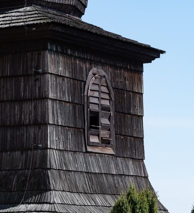 Zdjęcie nr 8: Kościół orientowany, murowany, jednonawowy z węższym prezbiterium zakończonym półkolistą absydą. Przy prezbiterium od północy znajduje się zakrystia, od południa kwadratowa kaplica św. Anny, a przy nawie od południa kruchta. Wnętrze kościoła nakryte jest nowym stropem, natomiast w kaplicy znajduje się sklepienie krzyżowo-żebrowe. Fasada zachodnia ujęta jest na narożnikach skośnymi szkarpami i zwieńczona schodkowym szczytem, podobnie zwieńczona jest kruchta południowa. Portal zachodni kamienny, z belkowaniem wspartym na dwóch liściastych konsolach ponad którymi edikula z płaskorzeźbionym krucyfiksem i klęczącymi postaciami męskimi. Na belkowaniu znajdują się dwa kartusze z herbami: po lewej herb Bończa, a nad nim litery „I” oraz „T”, a na prawo herb Szreniawa i litery „B” i „T”. Portal kruchty południowej jest również kamienny, podobny do zachodniego z inskrypcją: „IN LAVDEM ET GL[ORI]AM DEI O[MN]IP[OTENTIS] HO[NO]RE[M] / B(EATE) M(ARIAE) S(ANCTAE) V(IRGINIS) S(ANCTUS) AEGIDY ET OM(NIUM) SS. FIR. REGNÃTE [TERTIO] SIGISM[UN]DO / REGE POL[ONIAE] Z[?] HEMO[?] EP[ISCOP]O CRAC(OVIENSIS) BERN[AR]DO MACIEIOWSKI / NOVIT[ER] CAR[DINA]LI CRA[COVIENSE] DEI FACTO INTERI[M] PLEBA[N]O R[E]V[EREN]DO SEB(ASTIANO) / NAGRODIO A I SYRADIA PHI[LOSOPHI]AE DOCTORE COLLEG[I]A [MA]IORE / S. T(HEOLOGIAE) PVBLICO PROFES(SORE) PRAEP[OSI]TO S(ANCTA) AN(NAE) CRAC[OVIAE] DECIMARVM / ET FVNDI ECCL(ESIA)E HVIVS P[OST] IVRIS STREPITV(M) RESTITV / TORE ANNO OCTAVO PLEBANAT[U]S SVI. TEMPLVM HO(C) / [ dwa wiersze skute] DE' / NOWO AEDIFICATVM. ET. CONSTRVCTVM. ADIVTORIO / QVORVNDÃ ANNO D[OMINI] MDCIIII MENSE SEPTEMB[RE]”. Od południa świątyni umieszczone są trzy otwory okienne w kształcie stojących prostokątów, zamkniętych łukiem półkolistym, a w prezbiterium dwa małe okrągłe okna. Kościół nakryty jest dwoma dwuspadowymi dachami, nad prezbiterium nieco niższym, nad nawą zwieńczonym wąską i wysoką sygnaturką na dzwon. Wewnątrz świątyni na skrzyżowaniu nawy i prezbiterium umocowana jest drewniana belka tęczowa z ustawionym na niej krucyfiksem i figurami Matki Boskiej i św. Jana Ewangelisty. Chór zachodni drewniany, na planie prostokąta, pośrodku półkoliście zamknięty, wsparty na sześciu filarach, od północnego zachodu z obudowaną boazerią klatką schodową. 