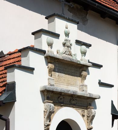 Zdjęcie nr 43: Kościół orientowany, murowany, jednonawowy z węższym prezbiterium zakończonym półkolistą absydą. Przy prezbiterium od północy znajduje się zakrystia, od południa kwadratowa kaplica św. Anny, a przy nawie od południa kruchta. Wnętrze kościoła nakryte jest nowym stropem, natomiast w kaplicy znajduje się sklepienie krzyżowo-żebrowe. Fasada zachodnia ujęta jest na narożnikach skośnymi szkarpami i zwieńczona schodkowym szczytem, podobnie zwieńczona jest kruchta południowa. Portal zachodni kamienny, z belkowaniem wspartym na dwóch liściastych konsolach ponad którymi edikula z płaskorzeźbionym krucyfiksem i klęczącymi postaciami męskimi. Na belkowaniu znajdują się dwa kartusze z herbami: po lewej herb Bończa, a nad nim litery „I” oraz „T”, a na prawo herb Szreniawa i litery „B” i „T”. Portal kruchty południowej jest również kamienny, podobny do zachodniego z inskrypcją: „IN LAVDEM ET GL[ORI]AM DEI O[MN]IP[OTENTIS] HO[NO]RE[M] / B(EATE) M(ARIAE) S(ANCTAE) V(IRGINIS) S(ANCTUS) AEGIDY ET OM(NIUM) SS. FIR. REGNÃTE [TERTIO] SIGISM[UN]DO / REGE POL[ONIAE] Z[?] HEMO[?] EP[ISCOP]O CRAC(OVIENSIS) BERN[AR]DO MACIEIOWSKI / NOVIT[ER] CAR[DINA]LI CRA[COVIENSE] DEI FACTO INTERI[M] PLEBA[N]O R[E]V[EREN]DO SEB(ASTIANO) / NAGRODIO A I SYRADIA PHI[LOSOPHI]AE DOCTORE COLLEG[I]A [MA]IORE / S. T(HEOLOGIAE) PVBLICO PROFES(SORE) PRAEP[OSI]TO S(ANCTA) AN(NAE) CRAC[OVIAE] DECIMARVM / ET FVNDI ECCL(ESIA)E HVIVS P[OST] IVRIS STREPITV(M) RESTITV / TORE ANNO OCTAVO PLEBANAT[U]S SVI. TEMPLVM HO(C) / [ dwa wiersze skute] DE&#039; / NOWO AEDIFICATVM. ET. CONSTRVCTVM. ADIVTORIO / QVORVNDÃ ANNO D[OMINI] MDCIIII MENSE SEPTEMB[RE]”. Od południa świątyni umieszczone są trzy otwory okienne w kształcie stojących prostokątów, zamkniętych łukiem półkolistym, a w prezbiterium dwa małe okrągłe okna. Kościół nakryty jest dwoma dwuspadowymi dachami, nad prezbiterium nieco niższym, nad nawą zwieńczonym wąską i wysoką sygnaturką na dzwon. Wewnątrz świątyni na skrzyżowaniu nawy i prezbiterium umocowana jest drewniana belka tęczowa z ustawionym na niej krucyfiksem i figurami Matki Boskiej i św. Jana Ewangelisty. Chór zachodni drewniany, na planie prostokąta, pośrodku półkoliście zamknięty, wsparty na sześciu filarach, od północnego zachodu z obudowaną boazerią klatką schodową. 