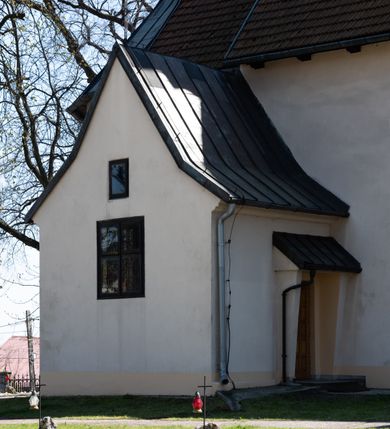 Zdjęcie nr 22: Kościół orientowany, murowany, jednonawowy z węższym prezbiterium zakończonym półkolistą absydą. Przy prezbiterium od północy znajduje się zakrystia, od południa kwadratowa kaplica św. Anny, a przy nawie od południa kruchta. Wnętrze kościoła nakryte jest nowym stropem, natomiast w kaplicy znajduje się sklepienie krzyżowo-żebrowe. Fasada zachodnia ujęta jest na narożnikach skośnymi szkarpami i zwieńczona schodkowym szczytem, podobnie zwieńczona jest kruchta południowa. Portal zachodni kamienny, z belkowaniem wspartym na dwóch liściastych konsolach ponad którymi edikula z płaskorzeźbionym krucyfiksem i klęczącymi postaciami męskimi. Na belkowaniu znajdują się dwa kartusze z herbami: po lewej herb Bończa, a nad nim litery „I” oraz „T”, a na prawo herb Szreniawa i litery „B” i „T”. Portal kruchty południowej jest również kamienny, podobny do zachodniego z inskrypcją: „IN LAVDEM ET GL[ORI]AM DEI O[MN]IP[OTENTIS] HO[NO]RE[M] / B(EATE) M(ARIAE) S(ANCTAE) V(IRGINIS) S(ANCTUS) AEGIDY ET OM(NIUM) SS. FIR. REGNÃTE [TERTIO] SIGISM[UN]DO / REGE POL[ONIAE] Z[?] HEMO[?] EP[ISCOP]O CRAC(OVIENSIS) BERN[AR]DO MACIEIOWSKI / NOVIT[ER] CAR[DINA]LI CRA[COVIENSE] DEI FACTO INTERI[M] PLEBA[N]O R[E]V[EREN]DO SEB(ASTIANO) / NAGRODIO A I SYRADIA PHI[LOSOPHI]AE DOCTORE COLLEG[I]A [MA]IORE / S. T(HEOLOGIAE) PVBLICO PROFES(SORE) PRAEP[OSI]TO S(ANCTA) AN(NAE) CRAC[OVIAE] DECIMARVM / ET FVNDI ECCL(ESIA)E HVIVS P[OST] IVRIS STREPITV(M) RESTITV / TORE ANNO OCTAVO PLEBANAT[U]S SVI. TEMPLVM HO(C) / [ dwa wiersze skute] DE' / NOWO AEDIFICATVM. ET. CONSTRVCTVM. ADIVTORIO / QVORVNDÃ ANNO D[OMINI] MDCIIII MENSE SEPTEMB[RE]”. Od południa świątyni umieszczone są trzy otwory okienne w kształcie stojących prostokątów, zamkniętych łukiem półkolistym, a w prezbiterium dwa małe okrągłe okna. Kościół nakryty jest dwoma dwuspadowymi dachami, nad prezbiterium nieco niższym, nad nawą zwieńczonym wąską i wysoką sygnaturką na dzwon. Wewnątrz świątyni na skrzyżowaniu nawy i prezbiterium umocowana jest drewniana belka tęczowa z ustawionym na niej krucyfiksem i figurami Matki Boskiej i św. Jana Ewangelisty. Chór zachodni drewniany, na planie prostokąta, pośrodku półkoliście zamknięty, wsparty na sześciu filarach, od północnego zachodu z obudowaną boazerią klatką schodową. 