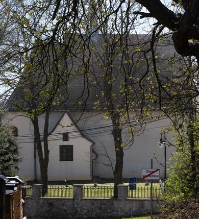 Zdjęcie nr 20: Kościół orientowany, murowany, jednonawowy z węższym prezbiterium zakończonym półkolistą absydą. Przy prezbiterium od północy znajduje się zakrystia, od południa kwadratowa kaplica św. Anny, a przy nawie od południa kruchta. Wnętrze kościoła nakryte jest nowym stropem, natomiast w kaplicy znajduje się sklepienie krzyżowo-żebrowe. Fasada zachodnia ujęta jest na narożnikach skośnymi szkarpami i zwieńczona schodkowym szczytem, podobnie zwieńczona jest kruchta południowa. Portal zachodni kamienny, z belkowaniem wspartym na dwóch liściastych konsolach ponad którymi edikula z płaskorzeźbionym krucyfiksem i klęczącymi postaciami męskimi. Na belkowaniu znajdują się dwa kartusze z herbami: po lewej herb Bończa, a nad nim litery „I” oraz „T”, a na prawo herb Szreniawa i litery „B” i „T”. Portal kruchty południowej jest również kamienny, podobny do zachodniego z inskrypcją: „IN LAVDEM ET GL[ORI]AM DEI O[MN]IP[OTENTIS] HO[NO]RE[M] / B(EATE) M(ARIAE) S(ANCTAE) V(IRGINIS) S(ANCTUS) AEGIDY ET OM(NIUM) SS. FIR. REGNÃTE [TERTIO] SIGISM[UN]DO / REGE POL[ONIAE] Z[?] HEMO[?] EP[ISCOP]O CRAC(OVIENSIS) BERN[AR]DO MACIEIOWSKI / NOVIT[ER] CAR[DINA]LI CRA[COVIENSE] DEI FACTO INTERI[M] PLEBA[N]O R[E]V[EREN]DO SEB(ASTIANO) / NAGRODIO A I SYRADIA PHI[LOSOPHI]AE DOCTORE COLLEG[I]A [MA]IORE / S. T(HEOLOGIAE) PVBLICO PROFES(SORE) PRAEP[OSI]TO S(ANCTA) AN(NAE) CRAC[OVIAE] DECIMARVM / ET FVNDI ECCL(ESIA)E HVIVS P[OST] IVRIS STREPITV(M) RESTITV / TORE ANNO OCTAVO PLEBANAT[U]S SVI. TEMPLVM HO(C) / [ dwa wiersze skute] DE' / NOWO AEDIFICATVM. ET. CONSTRVCTVM. ADIVTORIO / QVORVNDÃ ANNO D[OMINI] MDCIIII MENSE SEPTEMB[RE]”. Od południa świątyni umieszczone są trzy otwory okienne w kształcie stojących prostokątów, zamkniętych łukiem półkolistym, a w prezbiterium dwa małe okrągłe okna. Kościół nakryty jest dwoma dwuspadowymi dachami, nad prezbiterium nieco niższym, nad nawą zwieńczonym wąską i wysoką sygnaturką na dzwon. Wewnątrz świątyni na skrzyżowaniu nawy i prezbiterium umocowana jest drewniana belka tęczowa z ustawionym na niej krucyfiksem i figurami Matki Boskiej i św. Jana Ewangelisty. Chór zachodni drewniany, na planie prostokąta, pośrodku półkoliście zamknięty, wsparty na sześciu filarach, od północnego zachodu z obudowaną boazerią klatką schodową. 