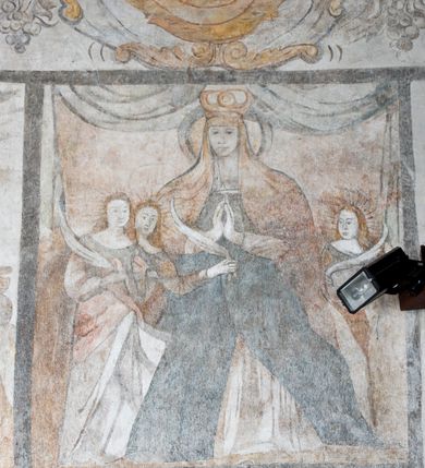 Zdjęcie nr 2: Na ścianie północnej prezbiterium w pierwszej kwaterze od lewej strony została ukazana św. Barbara z mieczem w lewej dłoni i palmą męczeństwa w prawej. W kolejnej kwaterze freski nie zachowały się w całości. W górnej części podwieszone są drapowane tkaniny, po lewej stronie widać dwie uskrzydlone główki aniołków, a po prawej stronie postać nierozpoznanej świętej męczennicy z palmą męczeństwa i księgą w dłoniach. Na ścianie południowej prezbiterium po prawej stronie jest przedstawienie św. Zofii z córkami ujęte w kwaterę w kształcie leżącego prostokąta. Pośrodku znajduje się św. Zofia z rękami złożonymi do modlitwy, na głowie ma zamkniętą koronę, po jej prawie stronie stoją dwie córki, a po lewej trzecia córka. Wszystkie córki zostały ukazane z palmami męczeństwa w dłoniach. Pozostałą powierzchnię ściany wypełniają dekoracje ornamentalne, uskrzydlone anioły, a w dolnej partii zacheuszki. Łuk arkady zdobią arma Christi, które otwierają kolejny cykl przedstawień w kaplicy św. Anny. Prezbiterium obiega od góry szeroki fryz z podwieszoną draperią, pomiędzy którą ukazane są winne grona.