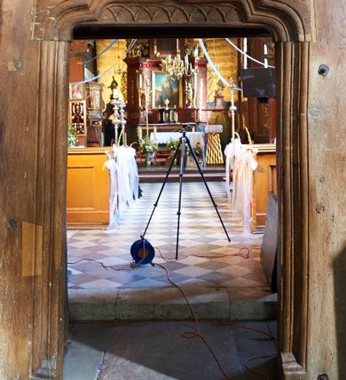 Zdjęcie nr 64: Kościół orientowany, pierwotnie na rzucie krzyża łacińskiego, jednonawowy, z kaplicami bocznymi od północy i południa, z prezbiterium prostokątnym zamkniętym wielobocznie. Obecnie w miejscu drewnianej kaplicy północnej murowana kaplica grobowa, a przy prezbiterium murowana prostokątna zakrystia i skarbczyk (1622 r.); nawa przedłużona ku zachodowi (1878-1879). Przy zachodniej części nawy, od południa, prostokątna drewniana kruchta. Wewnątrz stropy, w kaplicy północnej sklepienie krzyżowe z lunetami, w zakrystii i skarbczyku kolebkowe z lunetami. Zewnątrz zaszalowany. Dach nad nawą i prezbiterium jednokalenicowy, dwuspadowy o załamanych połaciach. Na kalenicy baniasta wieżyczka na sygnaturkę. Odrzwia zachodnie z nadprożem ozdobionym trójliściem z łukiem w ośli grzbiet oraz fryzem arkadkowym; odrzwia z prezbiterium do zakrystii z nadprożem ozdobionym łukiem w ośli grzbiet.