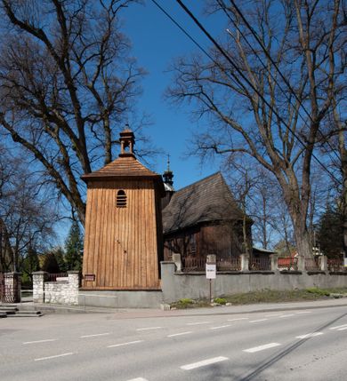 Zdjęcie nr 2: Kościół orientowany, pierwotnie na rzucie krzyża łacińskiego, jednonawowy, z kaplicami bocznymi od północy i południa, z prezbiterium prostokątnym zamkniętym wielobocznie. Obecnie w miejscu drewnianej kaplicy północnej murowana kaplica grobowa, a przy prezbiterium murowana prostokątna zakrystia i skarbczyk (1622 r.); nawa przedłużona ku zachodowi (1878-1879). Przy zachodniej części nawy, od południa, prostokątna drewniana kruchta. Wewnątrz stropy, w kaplicy północnej sklepienie krzyżowe z lunetami, w zakrystii i skarbczyku kolebkowe z lunetami. Zewnątrz zaszalowany. Dach nad nawą i prezbiterium jednokalenicowy, dwuspadowy o załamanych połaciach. Na kalenicy baniasta wieżyczka na sygnaturkę. Odrzwia zachodnie z nadprożem ozdobionym trójliściem z łukiem w ośli grzbiet oraz fryzem arkadkowym; odrzwia z prezbiterium do zakrystii z nadprożem ozdobionym łukiem w ośli grzbiet.
