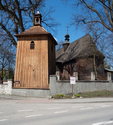 Zdjęcie nr 3: Kościół orientowany, pierwotnie na rzucie krzyża łacińskiego, jednonawowy, z kaplicami bocznymi od północy i południa, z prezbiterium prostokątnym zamkniętym wielobocznie. Obecnie w miejscu drewnianej kaplicy północnej murowana kaplica grobowa, a przy prezbiterium murowana prostokątna zakrystia i skarbczyk (1622 r.); nawa przedłużona ku zachodowi (1878-1879). Przy zachodniej części nawy, od południa, prostokątna drewniana kruchta. Wewnątrz stropy, w kaplicy północnej sklepienie krzyżowe z lunetami, w zakrystii i skarbczyku kolebkowe z lunetami. Zewnątrz zaszalowany. Dach nad nawą i prezbiterium jednokalenicowy, dwuspadowy o załamanych połaciach. Na kalenicy baniasta wieżyczka na sygnaturkę. Odrzwia zachodnie z nadprożem ozdobionym trójliściem z łukiem w ośli grzbiet oraz fryzem arkadkowym; odrzwia z prezbiterium do zakrystii z nadprożem ozdobionym łukiem w ośli grzbiet.