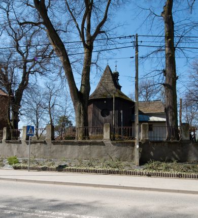 Zdjęcie nr 18: Kościół orientowany, pierwotnie na rzucie krzyża łacińskiego, jednonawowy, z kaplicami bocznymi od północy i południa, z prezbiterium prostokątnym zamkniętym wielobocznie. Obecnie w miejscu drewnianej kaplicy północnej murowana kaplica grobowa, a przy prezbiterium murowana prostokątna zakrystia i skarbczyk (1622 r.); nawa przedłużona ku zachodowi (1878-1879). Przy zachodniej części nawy, od południa, prostokątna drewniana kruchta. Wewnątrz stropy, w kaplicy północnej sklepienie krzyżowe z lunetami, w zakrystii i skarbczyku kolebkowe z lunetami. Zewnątrz zaszalowany. Dach nad nawą i prezbiterium jednokalenicowy, dwuspadowy o załamanych połaciach. Na kalenicy baniasta wieżyczka na sygnaturkę. Odrzwia zachodnie z nadprożem ozdobionym trójliściem z łukiem w ośli grzbiet oraz fryzem arkadkowym; odrzwia z prezbiterium do zakrystii z nadprożem ozdobionym łukiem w ośli grzbiet.