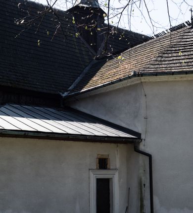 Zdjęcie nr 28: Kościół orientowany, pierwotnie na rzucie krzyża łacińskiego, jednonawowy, z kaplicami bocznymi od północy i południa, z prezbiterium prostokątnym zamkniętym wielobocznie. Obecnie w miejscu drewnianej kaplicy północnej murowana kaplica grobowa, a przy prezbiterium murowana prostokątna zakrystia i skarbczyk (1622 r.); nawa przedłużona ku zachodowi (1878-1879). Przy zachodniej części nawy, od południa, prostokątna drewniana kruchta. Wewnątrz stropy, w kaplicy północnej sklepienie krzyżowe z lunetami, w zakrystii i skarbczyku kolebkowe z lunetami. Zewnątrz zaszalowany. Dach nad nawą i prezbiterium jednokalenicowy, dwuspadowy o załamanych połaciach. Na kalenicy baniasta wieżyczka na sygnaturkę. Odrzwia zachodnie z nadprożem ozdobionym trójliściem z łukiem w ośli grzbiet oraz fryzem arkadkowym; odrzwia z prezbiterium do zakrystii z nadprożem ozdobionym łukiem w ośli grzbiet.