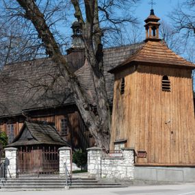 Zdjęcie nr 1: Kościół orientowany, pierwotnie na rzucie krzyża łacińskiego, jednonawowy, z kaplicami bocznymi od północy i południa, z prezbiterium prostokątnym zamkniętym wielobocznie. Obecnie w miejscu drewnianej kaplicy północnej murowana kaplica grobowa, a przy prezbiterium murowana prostokątna zakrystia i skarbczyk (1622 r.); nawa przedłużona ku zachodowi (1878-1879). Przy zachodniej części nawy, od południa, prostokątna drewniana kruchta. Wewnątrz stropy, w kaplicy północnej sklepienie krzyżowe z lunetami, w zakrystii i skarbczyku kolebkowe z lunetami. Zewnątrz zaszalowany. Dach nad nawą i prezbiterium jednokalenicowy, dwuspadowy o załamanych połaciach. Na kalenicy baniasta wieżyczka na sygnaturkę. Odrzwia zachodnie z nadprożem ozdobionym trójliściem z łukiem w ośli grzbiet oraz fryzem arkadkowym; odrzwia z prezbiterium do zakrystii z nadprożem ozdobionym łukiem w ośli grzbiet.