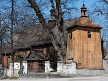 Zdjęcie nr 1: Kościół orientowany, pierwotnie na rzucie krzyża łacińskiego, jednonawowy, z kaplicami bocznymi od północy i południa, z prezbiterium prostokątnym zamkniętym wielobocznie. Obecnie w miejscu drewnianej kaplicy północnej murowana kaplica grobowa, a przy prezbiterium murowana prostokątna zakrystia i skarbczyk (1622 r.); nawa przedłużona ku zachodowi (1878-1879). Przy zachodniej części nawy, od południa, prostokątna drewniana kruchta. Wewnątrz stropy, w kaplicy północnej sklepienie krzyżowe z lunetami, w zakrystii i skarbczyku kolebkowe z lunetami. Zewnątrz zaszalowany. Dach nad nawą i prezbiterium jednokalenicowy, dwuspadowy o załamanych połaciach. Na kalenicy baniasta wieżyczka na sygnaturkę. Odrzwia zachodnie z nadprożem ozdobionym trójliściem z łukiem w ośli grzbiet oraz fryzem arkadkowym; odrzwia z prezbiterium do zakrystii z nadprożem ozdobionym łukiem w ośli grzbiet.