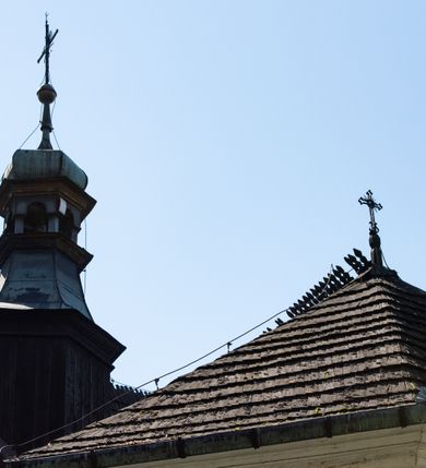 Zdjęcie nr 31: Kościół orientowany, pierwotnie na rzucie krzyża łacińskiego, jednonawowy, z kaplicami bocznymi od północy i południa, z prezbiterium prostokątnym zamkniętym wielobocznie. Obecnie w miejscu drewnianej kaplicy północnej murowana kaplica grobowa, a przy prezbiterium murowana prostokątna zakrystia i skarbczyk (1622 r.); nawa przedłużona ku zachodowi (1878-1879). Przy zachodniej części nawy, od południa, prostokątna drewniana kruchta. Wewnątrz stropy, w kaplicy północnej sklepienie krzyżowe z lunetami, w zakrystii i skarbczyku kolebkowe z lunetami. Zewnątrz zaszalowany. Dach nad nawą i prezbiterium jednokalenicowy, dwuspadowy o załamanych połaciach. Na kalenicy baniasta wieżyczka na sygnaturkę. Odrzwia zachodnie z nadprożem ozdobionym trójliściem z łukiem w ośli grzbiet oraz fryzem arkadkowym; odrzwia z prezbiterium do zakrystii z nadprożem ozdobionym łukiem w ośli grzbiet.