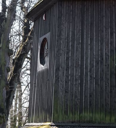 Zdjęcie nr 51: Kościół orientowany, pierwotnie na rzucie krzyża łacińskiego, jednonawowy, z kaplicami bocznymi od północy i południa, z prezbiterium prostokątnym zamkniętym wielobocznie. Obecnie w miejscu drewnianej kaplicy północnej murowana kaplica grobowa, a przy prezbiterium murowana prostokątna zakrystia i skarbczyk (1622 r.); nawa przedłużona ku zachodowi (1878-1879). Przy zachodniej części nawy, od południa, prostokątna drewniana kruchta. Wewnątrz stropy, w kaplicy północnej sklepienie krzyżowe z lunetami, w zakrystii i skarbczyku kolebkowe z lunetami. Zewnątrz zaszalowany. Dach nad nawą i prezbiterium jednokalenicowy, dwuspadowy o załamanych połaciach. Na kalenicy baniasta wieżyczka na sygnaturkę. Odrzwia zachodnie z nadprożem ozdobionym trójliściem z łukiem w ośli grzbiet oraz fryzem arkadkowym; odrzwia z prezbiterium do zakrystii z nadprożem ozdobionym łukiem w ośli grzbiet.