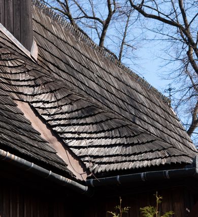 Zdjęcie nr 33: Kościół orientowany, pierwotnie na rzucie krzyża łacińskiego, jednonawowy, z kaplicami bocznymi od północy i południa, z prezbiterium prostokątnym zamkniętym wielobocznie. Obecnie w miejscu drewnianej kaplicy północnej murowana kaplica grobowa, a przy prezbiterium murowana prostokątna zakrystia i skarbczyk (1622 r.); nawa przedłużona ku zachodowi (1878-1879). Przy zachodniej części nawy, od południa, prostokątna drewniana kruchta. Wewnątrz stropy, w kaplicy północnej sklepienie krzyżowe z lunetami, w zakrystii i skarbczyku kolebkowe z lunetami. Zewnątrz zaszalowany. Dach nad nawą i prezbiterium jednokalenicowy, dwuspadowy o załamanych połaciach. Na kalenicy baniasta wieżyczka na sygnaturkę. Odrzwia zachodnie z nadprożem ozdobionym trójliściem z łukiem w ośli grzbiet oraz fryzem arkadkowym; odrzwia z prezbiterium do zakrystii z nadprożem ozdobionym łukiem w ośli grzbiet.