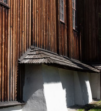 Zdjęcie nr 16: Kościół orientowany, pierwotnie na rzucie krzyża łacińskiego, jednonawowy, z kaplicami bocznymi od północy i południa, z prezbiterium prostokątnym zamkniętym wielobocznie. Obecnie w miejscu drewnianej kaplicy północnej murowana kaplica grobowa, a przy prezbiterium murowana prostokątna zakrystia i skarbczyk (1622 r.); nawa przedłużona ku zachodowi (1878-1879). Przy zachodniej części nawy, od południa, prostokątna drewniana kruchta. Wewnątrz stropy, w kaplicy północnej sklepienie krzyżowe z lunetami, w zakrystii i skarbczyku kolebkowe z lunetami. Zewnątrz zaszalowany. Dach nad nawą i prezbiterium jednokalenicowy, dwuspadowy o załamanych połaciach. Na kalenicy baniasta wieżyczka na sygnaturkę. Odrzwia zachodnie z nadprożem ozdobionym trójliściem z łukiem w ośli grzbiet oraz fryzem arkadkowym; odrzwia z prezbiterium do zakrystii z nadprożem ozdobionym łukiem w ośli grzbiet.