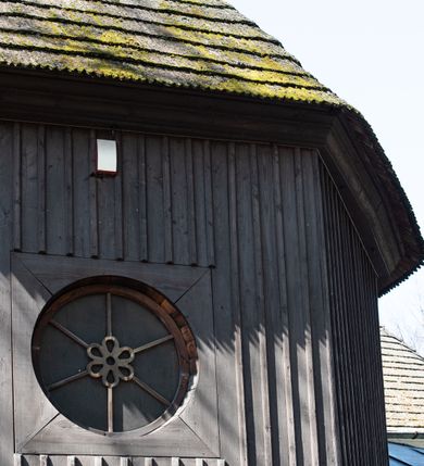 Zdjęcie nr 53: Kościół orientowany, pierwotnie na rzucie krzyża łacińskiego, jednonawowy, z kaplicami bocznymi od północy i południa, z prezbiterium prostokątnym zamkniętym wielobocznie. Obecnie w miejscu drewnianej kaplicy północnej murowana kaplica grobowa, a przy prezbiterium murowana prostokątna zakrystia i skarbczyk (1622 r.); nawa przedłużona ku zachodowi (1878-1879). Przy zachodniej części nawy, od południa, prostokątna drewniana kruchta. Wewnątrz stropy, w kaplicy północnej sklepienie krzyżowe z lunetami, w zakrystii i skarbczyku kolebkowe z lunetami. Zewnątrz zaszalowany. Dach nad nawą i prezbiterium jednokalenicowy, dwuspadowy o załamanych połaciach. Na kalenicy baniasta wieżyczka na sygnaturkę. Odrzwia zachodnie z nadprożem ozdobionym trójliściem z łukiem w ośli grzbiet oraz fryzem arkadkowym; odrzwia z prezbiterium do zakrystii z nadprożem ozdobionym łukiem w ośli grzbiet.