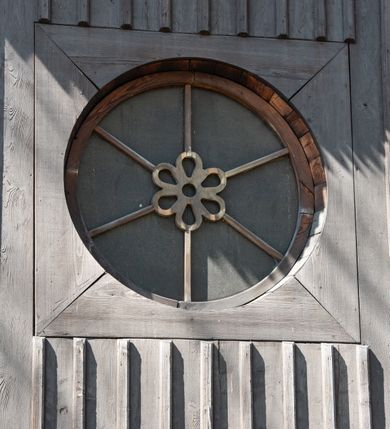 Zdjęcie nr 55: Kościół orientowany, pierwotnie na rzucie krzyża łacińskiego, jednonawowy, z kaplicami bocznymi od północy i południa, z prezbiterium prostokątnym zamkniętym wielobocznie. Obecnie w miejscu drewnianej kaplicy północnej murowana kaplica grobowa, a przy prezbiterium murowana prostokątna zakrystia i skarbczyk (1622 r.); nawa przedłużona ku zachodowi (1878-1879). Przy zachodniej części nawy, od południa, prostokątna drewniana kruchta. Wewnątrz stropy, w kaplicy północnej sklepienie krzyżowe z lunetami, w zakrystii i skarbczyku kolebkowe z lunetami. Zewnątrz zaszalowany. Dach nad nawą i prezbiterium jednokalenicowy, dwuspadowy o załamanych połaciach. Na kalenicy baniasta wieżyczka na sygnaturkę. Odrzwia zachodnie z nadprożem ozdobionym trójliściem z łukiem w ośli grzbiet oraz fryzem arkadkowym; odrzwia z prezbiterium do zakrystii z nadprożem ozdobionym łukiem w ośli grzbiet.