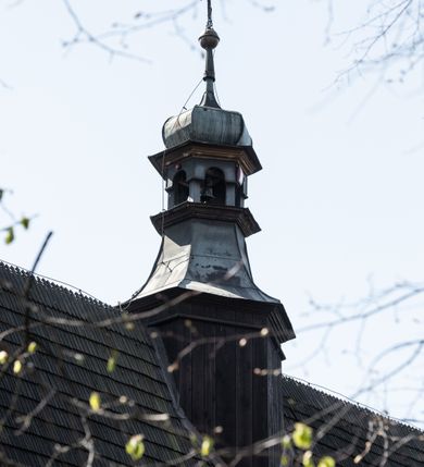 Zdjęcie nr 36: Kościół orientowany, pierwotnie na rzucie krzyża łacińskiego, jednonawowy, z kaplicami bocznymi od północy i południa, z prezbiterium prostokątnym zamkniętym wielobocznie. Obecnie w miejscu drewnianej kaplicy północnej murowana kaplica grobowa, a przy prezbiterium murowana prostokątna zakrystia i skarbczyk (1622 r.); nawa przedłużona ku zachodowi (1878-1879). Przy zachodniej części nawy, od południa, prostokątna drewniana kruchta. Wewnątrz stropy, w kaplicy północnej sklepienie krzyżowe z lunetami, w zakrystii i skarbczyku kolebkowe z lunetami. Zewnątrz zaszalowany. Dach nad nawą i prezbiterium jednokalenicowy, dwuspadowy o załamanych połaciach. Na kalenicy baniasta wieżyczka na sygnaturkę. Odrzwia zachodnie z nadprożem ozdobionym trójliściem z łukiem w ośli grzbiet oraz fryzem arkadkowym; odrzwia z prezbiterium do zakrystii z nadprożem ozdobionym łukiem w ośli grzbiet.
