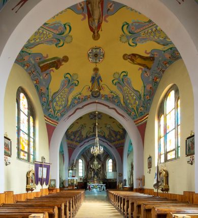 Zdjęcie nr 3: Kościół na planie krzyża łacińskiego, jednonawowy, z transeptem, zamknięty trójbocznym prezbiterium od północy i dobudowaną do niego zakrystią; na skrzyżowaniu nawy głównej i ramion transeptu wieżyczka na sygnaturkę. Fasadę tworzy masywna wieża, zwieńczona hełmem pokrytym blachą miedzianą. Główne wejście do kościoła od strony południowej, poprzez neoromański portal; wejścia boczne zlokalizowane od wschodu i zachodu, na styku nawy głównej i transeptu poprzez niewielkie kruchty. W oknach, w nawie współczesne witraże przedstawiające tajemnice różańca świętego; w prezbiterium Chrystusa ukrzyżowanego, św. Jana Pawła II i kardynała Stefana Wyszyńskiego, a w transepcie świętych zakonników: M. M. Alacoque, brata Alberta i siostrę Faustynę oraz św. Maksymiliana Marię Kolbego i bł. księdza Jerzego Popiełuszkę.
