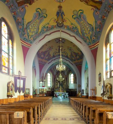 Zdjęcie nr 27: Kościół na planie krzyża łacińskiego, jednonawowy, z transeptem, zamknięty trójbocznym prezbiterium od północy i dobudowaną do niego zakrystią; na skrzyżowaniu nawy głównej i ramion transeptu wieżyczka na sygnaturkę. Fasadę tworzy masywna wieża, zwieńczona hełmem pokrytym blachą miedzianą. Główne wejście do kościoła od strony południowej, poprzez neoromański portal; wejścia boczne zlokalizowane od wschodu i zachodu, na styku nawy głównej i transeptu poprzez niewielkie kruchty. W oknach, w nawie współczesne witraże przedstawiające tajemnice różańca świętego; w prezbiterium Chrystusa ukrzyżowanego, św. Jana Pawła II i kardynała Stefana Wyszyńskiego, a w transepcie świętych zakonników: M. M. Alacoque, brata Alberta i siostrę Faustynę oraz św. Maksymiliana Marię Kolbego i bł. księdza Jerzego Popiełuszkę.
