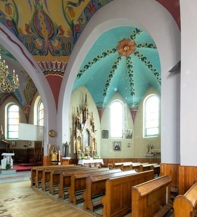 Zdjęcie nr 8: Kościół na planie krzyża łacińskiego, jednonawowy, z transeptem, zamknięty trójbocznym prezbiterium od północy i dobudowaną do niego zakrystią; na skrzyżowaniu nawy głównej i ramion transeptu wieżyczka na sygnaturkę. Fasadę tworzy masywna wieża, zwieńczona hełmem pokrytym blachą miedzianą. Główne wejście do kościoła od strony południowej, poprzez neoromański portal; wejścia boczne zlokalizowane od wschodu i zachodu, na styku nawy głównej i transeptu poprzez niewielkie kruchty. W oknach, w nawie współczesne witraże przedstawiające tajemnice różańca świętego; w prezbiterium Chrystusa ukrzyżowanego, św. Jana Pawła II i kardynała Stefana Wyszyńskiego, a w transepcie świętych zakonników: M. M. Alacoque, brata Alberta i siostrę Faustynę oraz św. Maksymiliana Marię Kolbego i bł. księdza Jerzego Popiełuszkę.
