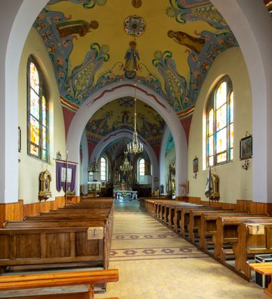 Zdjęcie nr 4: Kościół na planie krzyża łacińskiego, jednonawowy, z transeptem, zamknięty trójbocznym prezbiterium od północy i dobudowaną do niego zakrystią; na skrzyżowaniu nawy głównej i ramion transeptu wieżyczka na sygnaturkę. Fasadę tworzy masywna wieża, zwieńczona hełmem pokrytym blachą miedzianą. Główne wejście do kościoła od strony południowej, poprzez neoromański portal; wejścia boczne zlokalizowane od wschodu i zachodu, na styku nawy głównej i transeptu poprzez niewielkie kruchty. W oknach, w nawie współczesne witraże przedstawiające tajemnice różańca świętego; w prezbiterium Chrystusa ukrzyżowanego, św. Jana Pawła II i kardynała Stefana Wyszyńskiego, a w transepcie świętych zakonników: M. M. Alacoque, brata Alberta i siostrę Faustynę oraz św. Maksymiliana Marię Kolbego i bł. księdza Jerzego Popiełuszkę.
