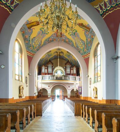 Zdjęcie nr 11: Kościół na planie krzyża łacińskiego, jednonawowy, z transeptem, zamknięty trójbocznym prezbiterium od północy i dobudowaną do niego zakrystią; na skrzyżowaniu nawy głównej i ramion transeptu wieżyczka na sygnaturkę. Fasadę tworzy masywna wieża, zwieńczona hełmem pokrytym blachą miedzianą. Główne wejście do kościoła od strony południowej, poprzez neoromański portal; wejścia boczne zlokalizowane od wschodu i zachodu, na styku nawy głównej i transeptu poprzez niewielkie kruchty. W oknach, w nawie współczesne witraże przedstawiające tajemnice różańca świętego; w prezbiterium Chrystusa ukrzyżowanego, św. Jana Pawła II i kardynała Stefana Wyszyńskiego, a w transepcie świętych zakonników: M. M. Alacoque, brata Alberta i siostrę Faustynę oraz św. Maksymiliana Marię Kolbego i bł. księdza Jerzego Popiełuszkę.
