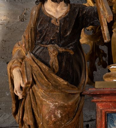 Zdjęcie nr 11: Nastawa ołtarzowa otrzymała formę jednokondygnacyjnej i jednoosiowej struktury architektonicznej wspartej na dwóch złoconych i kręconych kolumnach ze zwieńczeniem. Całość struktury pokryta jest marmoryzacją w kolorze palonej sieny. Drewniana mensa z portatylem o ściętych narożach wspiera się na prostopadłościennym stipesie ołtarzowym z fazowanym cokolikiem, ustawionym na stopniu. W miejscu ściętych naroży stipesu wprowadzono od frontu dwa srebrzone i złocone spływy wolutowe dodatkowo dekorowane motywem kampanuli. Przód stipesu zdobi jasna marmoryzacja oraz dwie poziome, płaskorzeźbione i złocone listwy z motywem ornamentu rocaille'owego umieszczone pod mensą i nad cokolikiem. W centrum retabulum znalazł się obraz Matki Boskiej z Dzieciątkiem w typie Piekarskim zdobiony drewnianą, złoconą sukienką wotywną. Ponad obrazem w profilowanych, złotych ramach umieszczono płaskorzeźbiony i złocony ornament z motywem suchego liścia akantowego, zamknięty fantazyjnym obramieniem. Obraz flankują dwie złocone, spiralne kolumny z korynckimi kapitelami o trzonach zdobionych wicią roślinno-kwiatową. Na wysokich postumentach, których boki zdobią płyciny ujęte w profilowane listwy, ustawiono kolumny. Pomiędzy postumentami pierwotnie znajdowało się niezachowane dziś tabernakulum, flankowane zachowaną po bokach ażurową, złoconą wicią roślinną. Kolumny podtrzymują wysokie imposty zdobione ornamentem roślinnym, na których wsparto wyłamane na środku i mocno wysunięte do przodu belkowanie. W części środkowej silnie artykułowane, wyłamane belkowanie podniesiono do góry wieńcząc go rzeźbionym owalem imitującym wieniec laurowy, wypełnionym malowanym przedstawieniem gołębicy Ducha Świętego. Otacza go ażurowa dekoracja utworzona ze złoconej, suchej wici akantowej oraz ustawiona na szczycie waza płomienista. Ponad belkowaniem na przedłużeniu kolumn, na wysokich cokołach, umieszczono figury aniołów z rozpostartymi skrzydłami, które w jednej ręce trzymają lance, a w drugiej kartusze herbowe. Anioł z lewej strony trzyma kartusz z godłem herbu Jastrzębiec, natomiast anioł z prawej kartusz z godłem herbu Kornicz. Po bokach kolumn ustawiono z lewej figurę św. Andrzeja Apostoła, a z prawej św. Mikołaja biskupa. Retabulum flankują dwa ażurowe, złocone uszaki utworzone ze stylizowanej suchej wici akantowej.