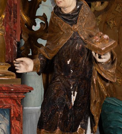 Zdjęcie nr 13: Nastawa ołtarzowa otrzymała formę jednokondygnacyjnej i jednoosiowej struktury architektonicznej wspartej na dwóch złoconych i kręconych kolumnach ze zwieńczeniem. Całość struktury pokryta jest marmoryzacją w kolorze palonej sieny. Drewniana mensa z portatylem o ściętych narożach wspiera się na prostopadłościennym stipesie ołtarzowym z fazowanym cokolikiem, ustawionym na stopniu. W miejscu ściętych naroży stipesu wprowadzono od frontu dwa srebrzone i złocone spływy wolutowe dodatkowo dekorowane motywem kampanuli. Przód stipesu zdobi jasna marmoryzacja oraz dwie poziome, płaskorzeźbione i złocone listwy z motywem ornamentu rocaille'owego umieszczone pod mensą i nad cokolikiem. W centrum retabulum znalazł się obraz Matki Boskiej z Dzieciątkiem w typie Piekarskim zdobiony drewnianą, złoconą sukienką wotywną. Ponad obrazem w profilowanych, złotych ramach umieszczono płaskorzeźbiony i złocony ornament z motywem suchego liścia akantowego, zamknięty fantazyjnym obramieniem. Obraz flankują dwie złocone, spiralne kolumny z korynckimi kapitelami o trzonach zdobionych wicią roślinno-kwiatową. Na wysokich postumentach, których boki zdobią płyciny ujęte w profilowane listwy, ustawiono kolumny. Pomiędzy postumentami pierwotnie znajdowało się niezachowane dziś tabernakulum, flankowane zachowaną po bokach ażurową, złoconą wicią roślinną. Kolumny podtrzymują wysokie imposty zdobione ornamentem roślinnym, na których wsparto wyłamane na środku i mocno wysunięte do przodu belkowanie. W części środkowej silnie artykułowane, wyłamane belkowanie podniesiono do góry wieńcząc go rzeźbionym owalem imitującym wieniec laurowy, wypełnionym malowanym przedstawieniem gołębicy Ducha Świętego. Otacza go ażurowa dekoracja utworzona ze złoconej, suchej wici akantowej oraz ustawiona na szczycie waza płomienista. Ponad belkowaniem na przedłużeniu kolumn, na wysokich cokołach, umieszczono figury aniołów z rozpostartymi skrzydłami, które w jednej ręce trzymają lance, a w drugiej kartusze herbowe. Anioł z lewej strony trzyma kartusz z godłem herbu Jastrzębiec, natomiast anioł z prawej kartusz z godłem herbu Kornicz. Po bokach kolumn ustawiono z lewej figurę św. Andrzeja Apostoła, a z prawej św. Mikołaja biskupa. Retabulum flankują dwa ażurowe, złocone uszaki utworzone ze stylizowanej suchej wici akantowej.