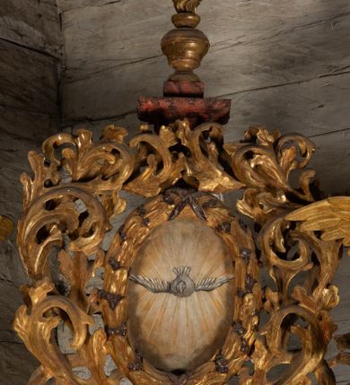 Zdjęcie nr 15: Nastawa ołtarzowa otrzymała formę jednokondygnacyjnej i jednoosiowej struktury architektonicznej wspartej na dwóch złoconych i kręconych kolumnach ze zwieńczeniem. Całość struktury pokryta jest marmoryzacją w kolorze palonej sieny. Drewniana mensa z portatylem o ściętych narożach wspiera się na prostopadłościennym stipesie ołtarzowym z fazowanym cokolikiem, ustawionym na stopniu. W miejscu ściętych naroży stipesu wprowadzono od frontu dwa srebrzone i złocone spływy wolutowe dodatkowo dekorowane motywem kampanuli. Przód stipesu zdobi jasna marmoryzacja oraz dwie poziome, płaskorzeźbione i złocone listwy z motywem ornamentu rocaille'owego umieszczone pod mensą i nad cokolikiem. W centrum retabulum znalazł się obraz Matki Boskiej z Dzieciątkiem w typie Piekarskim zdobiony drewnianą, złoconą sukienką wotywną. Ponad obrazem w profilowanych, złotych ramach umieszczono płaskorzeźbiony i złocony ornament z motywem suchego liścia akantowego, zamknięty fantazyjnym obramieniem. Obraz flankują dwie złocone, spiralne kolumny z korynckimi kapitelami o trzonach zdobionych wicią roślinno-kwiatową. Na wysokich postumentach, których boki zdobią płyciny ujęte w profilowane listwy, ustawiono kolumny. Pomiędzy postumentami pierwotnie znajdowało się niezachowane dziś tabernakulum, flankowane zachowaną po bokach ażurową, złoconą wicią roślinną. Kolumny podtrzymują wysokie imposty zdobione ornamentem roślinnym, na których wsparto wyłamane na środku i mocno wysunięte do przodu belkowanie. W części środkowej silnie artykułowane, wyłamane belkowanie podniesiono do góry wieńcząc go rzeźbionym owalem imitującym wieniec laurowy, wypełnionym malowanym przedstawieniem gołębicy Ducha Świętego. Otacza go ażurowa dekoracja utworzona ze złoconej, suchej wici akantowej oraz ustawiona na szczycie waza płomienista. Ponad belkowaniem na przedłużeniu kolumn, na wysokich cokołach, umieszczono figury aniołów z rozpostartymi skrzydłami, które w jednej ręce trzymają lance, a w drugiej kartusze herbowe. Anioł z lewej strony trzyma kartusz z godłem herbu Jastrzębiec, natomiast anioł z prawej kartusz z godłem herbu Kornicz. Po bokach kolumn ustawiono z lewej figurę św. Andrzeja Apostoła, a z prawej św. Mikołaja biskupa. Retabulum flankują dwa ażurowe, złocone uszaki utworzone ze stylizowanej suchej wici akantowej.