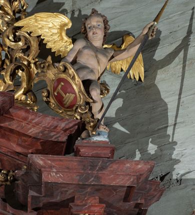 Zdjęcie nr 6: Nastawa ołtarzowa otrzymała formę jednokondygnacyjnej i jednoosiowej struktury architektonicznej wspartej na dwóch złoconych i kręconych kolumnach ze zwieńczeniem. Całość struktury pokryta jest marmoryzacją w kolorze palonej sieny. Drewniana mensa z portatylem o ściętych narożach wspiera się na prostopadłościennym stipesie ołtarzowym z fazowanym cokolikiem, ustawionym na stopniu. W miejscu ściętych naroży stipesu wprowadzono od frontu dwa srebrzone i złocone spływy wolutowe dodatkowo dekorowane motywem kampanuli. Przód stipesu zdobi jasna marmoryzacja oraz dwie poziome, płaskorzeźbione i złocone listwy z motywem ornamentu rocaille'owego umieszczone pod mensą i nad cokolikiem. W centrum retabulum znalazł się obraz Matki Boskiej z Dzieciątkiem w typie Piekarskim zdobiony drewnianą, złoconą sukienką wotywną. Ponad obrazem w profilowanych, złotych ramach umieszczono płaskorzeźbiony i złocony ornament z motywem suchego liścia akantowego, zamknięty fantazyjnym obramieniem. Obraz flankują dwie złocone, spiralne kolumny z korynckimi kapitelami o trzonach zdobionych wicią roślinno-kwiatową. Na wysokich postumentach, których boki zdobią płyciny ujęte w profilowane listwy, ustawiono kolumny. Pomiędzy postumentami pierwotnie znajdowało się niezachowane dziś tabernakulum, flankowane zachowaną po bokach ażurową, złoconą wicią roślinną. Kolumny podtrzymują wysokie imposty zdobione ornamentem roślinnym, na których wsparto wyłamane na środku i mocno wysunięte do przodu belkowanie. W części środkowej silnie artykułowane, wyłamane belkowanie podniesiono do góry wieńcząc go rzeźbionym owalem imitującym wieniec laurowy, wypełnionym malowanym przedstawieniem gołębicy Ducha Świętego. Otacza go ażurowa dekoracja utworzona ze złoconej, suchej wici akantowej oraz ustawiona na szczycie waza płomienista. Ponad belkowaniem na przedłużeniu kolumn, na wysokich cokołach, umieszczono figury aniołów z rozpostartymi skrzydłami, które w jednej ręce trzymają lance, a w drugiej kartusze herbowe. Anioł z lewej strony trzyma kartusz z godłem herbu Jastrzębiec, natomiast anioł z prawej kartusz z godłem herbu Kornicz. Po bokach kolumn ustawiono z lewej figurę św. Andrzeja Apostoła, a z prawej św. Mikołaja biskupa. Retabulum flankują dwa ażurowe, złocone uszaki utworzone ze stylizowanej suchej wici akantowej.