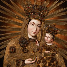 Zdjęcie nr 1: Obraz w kształcie prostokąta zbliżonego do kwadratu, ukazuje Matkę Boską z Dzieciątkiem w typie Hodegetrii krakowskiej. Drewniana, rzeźbiona i złocona sukienka wotywna przesłania obraz, odsłaniając jedynie twarze, dłonie, stopy oraz fragmenty tła. Matka Boska została ujęta frontalnie w półpostaci, trzymając na lewym przedramieniu małego Jezusa. Prawą dłonią zgiętej w łokciu ręki wskazuje na Dzieciątko, trzymając w niej równocześnie gruszkę, zaś lewą, opuszczoną, podtrzymuje jego stopy. Maria nieznacznie pochyla głowę w stronę Syna. Jej twarz ma jasną karnację o rumianych policzkach, duże, szeroko rozstawione oczy, prosty nos, wąskie usta i tylko częściowo widoczne ciemne włosy. Mały Jezus siedzi wyprostowany na lewym ramieniu Marii. Ma nieznacznie uniesioną głowę ze spojrzeniem skierowanym na matkę. Prawą ręką błogosławi, lewą zaś opiera na trzymanej na kolanach księdze Ewangelii. Jego owalna twarz o jasnej karnacji z rumianymi policzkami widoczna jest w trzech czwartych. Na głowie spod korony wotywnej widać jasne, krótkie włosy. Obie postacie okrywa drewniana, płaskorzeźbiona i złocona sukienka wotywna z koronami. Sukienka zapewne powtarza dukt maforionu Matki Boskiej oraz kształt i drapowanie długiej tuniki, która okrywa małego Jezusa. Szaty Marii dekorowane są płaskorzeźbionym ornamentem z motywem szerokolistnych gałązek z kwiatami w kształcie rozet, naśladujących kameryzacje. Malowana kameryzacja widoczna jest także na taśmach lamujących maforion oraz spodnią suknię pod szyją i na jej rękawach. Pod szyją Marii widać drewniany krzyżyk. Tunika Dzieciątka jest pokryta płaskorzeźbionymi rozetami z naśladowaniem malowanej kameryzacji. Obie postacie mają na głowach zamknięte, płaskorzeźbione i złocone korony z globem i krzyżykiem. Także one są dekorowane malowaną kameryzacją. Marię i Dzieciątko otaczają nakładane, płaskorzeźbione i złocone promienie, zakończone w jaskółczy ogon, ułożone na kształt glorii.