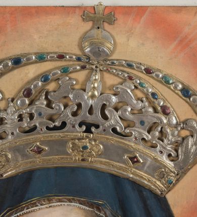 Zdjęcie nr 3: Dwustronnie malowany obraz ma kształt stojącego prostokąta zbliżonego do kwadratu. Ujmuje go szeroka, płaska rama, zdobiona grawerowanym pasem ornamentalnym składającym się z liści i kwiatów. Ornament zamykają złocone profile ramy. Na awersie obrazu wyobrażono Matkę Boską Szkaplerzną, a na rewersie Matkę Boską Bolesną w typie Piety. Matka Boska Szkaplerzna została przedstawiona frontalnie w półpostaci z lekko pochyloną głową w prawo i twarzą widoczną w trzech czwartych. Ubrana jest w czerwoną suknię okrytą niebieskim maforionem lamowanym złotą tasiemką. Spod niego uwidacznia się przeźroczysty welon osłaniający włosy. Jej twarz charakteryzuje łagodne spojrzenie skierowanych w dal, przed siebie, dużych, brązowych oczu. Maria ma jasną karnację, długi prosty nos i wąskie usta o lekko wydatnej dolnej wardze. W lewej dłoni Maryja ma szkaplerz. Do jej policzka tuli się Dzieciątko trzymane obiema rękami na prawym przedramieniu. Jezus lewą ręką chwyta się za podbródek Matki, także trzymając w prawej lekko zgiętej ręce szkaplerz. Dzieciątko ma pociągłą twarz otoczoną kręconymi, krótkimi, jasnymi włosami. Charakteryzuje ją wysokie czoło, rumiane policzki oraz mały nos i wąskie usta. Mały Jezus ubrany jest w złocisto-cynobrową tunikę odsłaniającą jego prawą rękę oraz prawą nóżkę przełożoną przez rękę Matki. Oba szkaplerze na obrazie zdobi niewielkie przedstawienie w półpostaci Matki Boskiej z Dzieciątkiem na obłoku. Trzymany przez Maryję szkaplerz przechodzi przez półkolisty łuk o architektonicznej strukturze widniejący pod postaciami w dolnej części obrazu. Pod nim przedstawiono dusze czyśćcowe w ognistych płomieniach. Postać Madonny i Dzieciątka otaczają świetliste nimby kontrastujące z złocisto-cynobrowym tłem obrazu. Na ich głowach przytwierdzone są w formie aplikacji srebrne, ażurowe i kameryzowane korony zamknięte, utworzone z ornamentu małżowinowo-chrząstkowego oraz akantowego, zwieńczone kulami z krzyżami równoramiennymi.