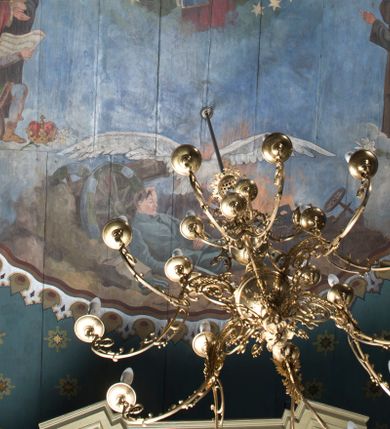 Zdjęcie nr 7: Polichromia pokrywa północną, południową i zachodnią ścianę nawy oraz arkadę ściany tęczowej. Od posadzki na wysokość około 1,5 m jednolity pas utrzymany w granatowej tonacji kolorystycznej, oddzielony powyżej pasem bordowo-złotego, przestylizowanego ornamentu geometrycznego. Nad nim wysoki pas jasnozielonego tła z białym, powtarzającym się ornamentem geometryczno-roślinnym, sięgającym pod zaskrzynienia. Na wysokości okien, po obu stronach cztery wydzielone pola w kształcie stojących prostokątów zakończonych ostrołukowo. Na ścianie północnej, bliżej ołtarza bocznego i ściany tęczowej scena wygnania z raju z Adamem i Ewą, Archaniołem Michałem, Bogiem Ojcem i Matką Boską Niepokalanie Poczętą. W drugim polu na tej samej ścianie, bliżej parapetu chóru muzycznego, scena stworzenia świata z Adamem i Ewą i zwierzętami przebywającymi w raju; powyżej, na obłoku zasiada Bóg Ojciec w otoczeniu aniołków. Analogiczna kompozycja układu pól znalazła się na ścianie południowej. Bliżej ołtarza bocznego scena przekazania kluczy św. Piotrowi przez Jezusa. W następnym polu znalazło się przedstawienie Sądu Ostatecznego z Bogiem Ojcem, Chrystusem, Matką Boską i św. Janem Chrzcicielem (Deesis) oraz duszami zbawionych i potępionych, o które spierają się aniołowie i diabły. Na ścianie tęczowej, po stronie północnej przy arkadzie łuku tęczowego przedstawienie króla Dawida grającego na harfie. Analogicznie, po drugiej stronie widnieje scena przekazania Dekalogu Mojżeszowi.

 Zaskrzynienia są wypełnione pasem powtarzającej się dekoracji geometrycznej, poprzedzielanej niewielkimi, smukłymi podziałami pionowymi imitującymi tralki, wypełnione kolorem bordowym i złotymi gwiazdkami. Tło stropu malowane jest na kolor jasnoniebieski z licznymi, symetrycznie ustawionymi gwiazdkami oraz przestylizowanymi gwiazdami w czterech narożach. Pośrodku stopu, okrągłe pole oddzielone zostało obramieniem utworzonym ze stylizowanych łez. Wewnątrz, centralne miejsce zajmuje scena koronacji Matki Boskiej przez dwóch aniołów, która trzyma za rękę małego Jezusa. Po obu stronach przedstawienia znalazły się postacie świętych związanych z historią Polski. Po lewej stronie stoją kolejno: św. Jacek, św. Florian, św. Wojciech, św. Jadwiga Śląska oraz klęczący św. Kazimierz. Po lewej stoją kolejno: bł. Kinga, bł. Bronisława, św. Stanisław, św. Jan Kanty i klęczy św. Stanisław Kostka. Poniżej sceny koronacji jest przedstawienie leżącego żołnierza w błękitnym mundurze legionowym, wspartego na kole armaty. Z prawej ręki wypada mu szabla, obok zaś leży rogatywka. W tle widać pożogę wojenną z poprzewracanymi wozami i armatami. Nad żołnierzem unosi się biały orzeł w koronie, który w szponach trzyma miecz.