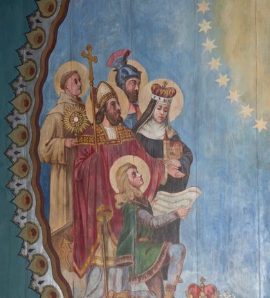 Zdjęcie nr 4: Polichromia pokrywa północną, południową i zachodnią ścianę nawy oraz arkadę ściany tęczowej. Od posadzki na wysokość około 1,5 m jednolity pas utrzymany w granatowej tonacji kolorystycznej, oddzielony powyżej pasem bordowo-złotego, przestylizowanego ornamentu geometrycznego. Nad nim wysoki pas jasnozielonego tła z białym, powtarzającym się ornamentem geometryczno-roślinnym, sięgającym pod zaskrzynienia. Na wysokości okien, po obu stronach cztery wydzielone pola w kształcie stojących prostokątów zakończonych ostrołukowo. Na ścianie północnej, bliżej ołtarza bocznego i ściany tęczowej scena wygnania z raju z Adamem i Ewą, Archaniołem Michałem, Bogiem Ojcem i Matką Boską Niepokalanie Poczętą. W drugim polu na tej samej ścianie, bliżej parapetu chóru muzycznego, scena stworzenia świata z Adamem i Ewą i zwierzętami przebywającymi w raju; powyżej, na obłoku zasiada Bóg Ojciec w otoczeniu aniołków. Analogiczna kompozycja układu pól znalazła się na ścianie południowej. Bliżej ołtarza bocznego scena przekazania kluczy św. Piotrowi przez Jezusa. W następnym polu znalazło się przedstawienie Sądu Ostatecznego z Bogiem Ojcem, Chrystusem, Matką Boską i św. Janem Chrzcicielem (Deesis) oraz duszami zbawionych i potępionych, o które spierają się aniołowie i diabły. Na ścianie tęczowej, po stronie północnej przy arkadzie łuku tęczowego przedstawienie króla Dawida grającego na harfie. Analogicznie, po drugiej stronie widnieje scena przekazania Dekalogu Mojżeszowi.

 Zaskrzynienia są wypełnione pasem powtarzającej się dekoracji geometrycznej, poprzedzielanej niewielkimi, smukłymi podziałami pionowymi imitującymi tralki, wypełnione kolorem bordowym i złotymi gwiazdkami. Tło stropu malowane jest na kolor jasnoniebieski z licznymi, symetrycznie ustawionymi gwiazdkami oraz przestylizowanymi gwiazdami w czterech narożach. Pośrodku stopu, okrągłe pole oddzielone zostało obramieniem utworzonym ze stylizowanych łez. Wewnątrz, centralne miejsce zajmuje scena koronacji Matki Boskiej przez dwóch aniołów, która trzyma za rękę małego Jezusa. Po obu stronach przedstawienia znalazły się postacie świętych związanych z historią Polski. Po lewej stronie stoją kolejno: św. Jacek, św. Florian, św. Wojciech, św. Jadwiga Śląska oraz klęczący św. Kazimierz. Po lewej stoją kolejno: bł. Kinga, bł. Bronisława, św. Stanisław, św. Jan Kanty i klęczy św. Stanisław Kostka. Poniżej sceny koronacji jest przedstawienie leżącego żołnierza w błękitnym mundurze legionowym, wspartego na kole armaty. Z prawej ręki wypada mu szabla, obok zaś leży rogatywka. W tle widać pożogę wojenną z poprzewracanymi wozami i armatami. Nad żołnierzem unosi się biały orzeł w koronie, który w szponach trzyma miecz.