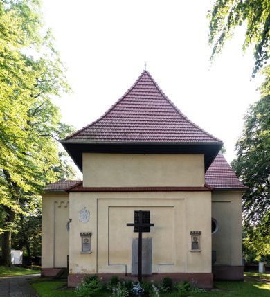 Zdjęcie nr 23: Kościół, otoczony starodrzewiem, położony jest na niewielkim wzniesieniu ponad stawami w centrum wsi. Jest to budowla drewniano-murowana, orientowana. Nawa została wzniesiona w 1518 roku na zrąb na rzucie zbliżonym do kwadratu, nakryta płaskim stropem. Od zachodu do nawy przylega wzniesiona w tym samym roku wieża o konstrukcji słupowej, pierwotnie kwadratowa o pochyłych ścianach, w 1782 roku poszerzona przez obudowanie drugą konstrukcją, prawie pionową. Wieża, w całości szalowana, poprzedzona niewielką kruchtą, w połowie wysokości jest opasana daszkiem pulpitowym. Jej hełm posiada kształt kopuły zwieńczonej ostrosłupem. Od południa do nawy przylega drewniana kruchta z 1924 roku, a od wschodu murowane prezbiterium z 1931 roku. Prezbiterium otwiera się podwójnymi arkadami na dwie kaplice boczne - wzniesioną od południa w 1861 roku z kryptą grobową Duninów oraz kaplicę przylegającą od północy zbudowaną w 1931 roku. Jego przestrzeń nakryto sklepieniem kolebkowym na gurtach, zaś dwuprzęsłowe kaplice sklepieniem krzyżowym. Za prezbiterium wznosi się murowana, piętrowa zakrystia z XVII wieku przykryta sklepieniem nieckowym z lunetami i małym zwierciadłem, zdobionym monogramem maryjnym. Jednokalenicowy dach nawy i prezbiterium pokryty jest dachówką. Nad końcu dachu nawy od wschodu nadwieszono wieżyczkę na sygnaturkę z latarnią i cebulastą banią, zwieńczoną krzyżem. Zakrystia nakryta została namiotowym dachem polskim, także pokrytym dachówką. Na zewnętrznych ścianach części murowanej umieszczono kilka epitafiów przeniesionych z wnętrza kościoła. Wewnątrz prezbiterium na ścianie wschodniej, nad wejściem do zakrystii, zawieszono manierystyczny, dwukondygnacyjny ołtarz główny z XVII wieku z uszakami zdobionymi herbami Starykoń i Jelita. Przy ścianie północnej, w miejscu połączenia nawy drewnianej z murowanym prezbiterium, usytuowano w 1931 roku ambonę oraz kamienną chrzcielnicę z 1658 roku. Belkę tęczową zdobi osiemnastowieczna grupa Ukrzyżowania. W kaplicach bocznych ustawiono dwa neobarokowe ołtarze boczne.  