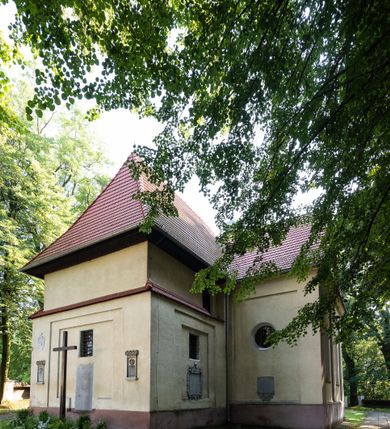 Zdjęcie nr 22: Kościół, otoczony starodrzewiem, położony jest na niewielkim wzniesieniu ponad stawami w centrum wsi. Jest to budowla drewniano-murowana, orientowana. Nawa została wzniesiona w 1518 roku na zrąb na rzucie zbliżonym do kwadratu, nakryta płaskim stropem. Od zachodu do nawy przylega wzniesiona w tym samym roku wieża o konstrukcji słupowej, pierwotnie kwadratowa o pochyłych ścianach, w 1782 roku poszerzona przez obudowanie drugą konstrukcją, prawie pionową. Wieża, w całości szalowana, poprzedzona niewielką kruchtą, w połowie wysokości jest opasana daszkiem pulpitowym. Jej hełm posiada kształt kopuły zwieńczonej ostrosłupem. Od południa do nawy przylega drewniana kruchta z 1924 roku, a od wschodu murowane prezbiterium z 1931 roku. Prezbiterium otwiera się podwójnymi arkadami na dwie kaplice boczne - wzniesioną od południa w 1861 roku z kryptą grobową Duninów oraz kaplicę przylegającą od północy zbudowaną w 1931 roku. Jego przestrzeń nakryto sklepieniem kolebkowym na gurtach, zaś dwuprzęsłowe kaplice sklepieniem krzyżowym. Za prezbiterium wznosi się murowana, piętrowa zakrystia z XVII wieku przykryta sklepieniem nieckowym z lunetami i małym zwierciadłem, zdobionym monogramem maryjnym. Jednokalenicowy dach nawy i prezbiterium pokryty jest dachówką. Nad końcu dachu nawy od wschodu nadwieszono wieżyczkę na sygnaturkę z latarnią i cebulastą banią, zwieńczoną krzyżem. Zakrystia nakryta została namiotowym dachem polskim, także pokrytym dachówką. Na zewnętrznych ścianach części murowanej umieszczono kilka epitafiów przeniesionych z wnętrza kościoła. Wewnątrz prezbiterium na ścianie wschodniej, nad wejściem do zakrystii, zawieszono manierystyczny, dwukondygnacyjny ołtarz główny z XVII wieku z uszakami zdobionymi herbami Starykoń i Jelita. Przy ścianie północnej, w miejscu połączenia nawy drewnianej z murowanym prezbiterium, usytuowano w 1931 roku ambonę oraz kamienną chrzcielnicę z 1658 roku. Belkę tęczową zdobi osiemnastowieczna grupa Ukrzyżowania. W kaplicach bocznych ustawiono dwa neobarokowe ołtarze boczne.  