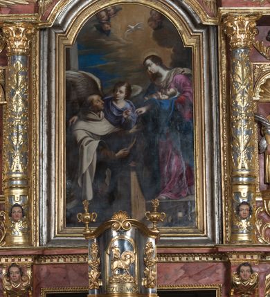 Zdjęcie nr 2: Obraz uzyskał kształt stojącego prostokąta zamkniętego nadwieszonym łukiem półkolistym. Ujmuje go profilowana, złocona rama. Wizerunek przedstawia Matkę Boską z Dzieciątkiem (Szkaplerzną), przekazującą szkaplerz św. Szymonowi Stockowi. Z prawej strony kompozycji w całej postaci w ujęciu trzech czwartych wyobrażono Madonnę patrzącą w prawo, trzymającą na lewym ramieniu leżące Dzieciątko. Matka Boska stoi w kontrapoście na wyraźnie zaznaczonym stopniu. Jej łagodna i bardzo subtelna, owalna twarz o jasnej karnacji, została ukazana z profilu. Madonna ma kształtny nos, wydatne usta, niski podbródek i szeroko otwarte, ciemne oczy. Jej długie, jasnobrązowe włosy, spięte nieznacznie z tyłu, opadają na odsłoniętą szyję i plecy. We włosy z tyłu głowy została wpleciona świetlistoochrowa chusta, stanowiąca tło dla profilu twarzy Matki Boskiej. Chusta opada na prawe ramię i zwiewnie oplatając szyję, przechodzi na ramiona i dalej na plecy. Wokół głowy Marii widoczny jest delikatny nimb promienisty. Madonna ubrana jest w niebieski płaszcz przerzucony przez prawe ramię. Poły płaszcza, okrywając jej ręce, opadają ku ziemi. Spod płaszcza widoczna jest szkarłatna suknia bez rękawów, spod której widać purpurowe rękawy spodniej tuniki. Prawą ręką Matka Boska podaje połę szkaplerza zakonnego św. Szymonowi Stockowi, podtrzymując równocześnie leżące na lewym ramieniu nagie Dzieciątko. Mały Jezus o jasnej karnacji został przedstawiony w trzech czwartych z lekko uniesionymi, zgiętymi w łokciach rączkami. Ma pucułowatą twarz z wysokim czołem i różowymi policzkami, kształtny nos i wydatne wargi. Jego widoczną z profilu głowę otaczają jasne, krótkie włosy. Wokół głowy zaznaczone zostały delikatne świetliste promienie tworzące nimb. Jezus spoczywa na białej pieluszce. Przed Madonną klęczy na drewnianym klęczniku św. Szymon Stock. Został on ukazany w trzech czwartych w lewo. Jest to mężczyzna posunięty w latach ze śniadą karnacją i twarzą pooraną zmarszczkami. Ma siwiejące krótkie włosy z widoczną łysiną nad czołem i podobnie siwiejący, krótki zarost. Jego pociągłą twarz charakteryzuje wyrazisty orli nos oraz szeroko otwarte oczy i wąskie usta. Święty z lekka unosi głowę, wpatrując się w Marię. Wyciągniętymi przed siebie obiema rękami przyjmuje od niej poły karmelitańskiego szkaplerza. Ubrany jest w karmelitański brązowy habit przepasany pasem, u którego wisi różaniec. Na ramiona ma nałożony biały płaszcz zakonny z kapturem opadającym na plecy. Za nim widoczny jest w ujęciu trzech czwartych w prawo skrzydlaty anioł. Swoją prawą ręką obejmuje za ramię św. Szymona, lewą zaś zdaje się unosić w geście mowy. Ma twarz o jasnej karnacji z różowymi policzkami. Charakteryzuje ją zadarty nos, szeroko otwarte ciemne oczy i wyraziste usta. Ubrany jest w luźną, fioletową tunikę. Ponad św. Szymonem Stockiem i Madonną unosi się gołębica Ducha Świętego na tle rozjaśnionych szaro-złocistych obłoków, ukazanych na tle błękitnego nieba. On też jest źródłem świetlistych promieni skierowanych na św. Szymona. Duchowi Świętemu towarzyszą z lewej strony trzy uskrzydlone główki anielskie, a z prawej dwie. Za świętym karmelitą i aniołem widoczny jest pionowy fragment architektoniczny. U podnóża stopnia, na którym stoi Madonna, w prawym dolnym rogu obrazu widać przewróconą ludzką czaszkę i stojącą obok złocistą misę z położonym na niej po przekątnej kropidłem.
