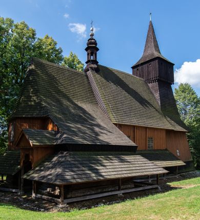 Zdjęcie nr 2: Kościół jest usytuowany ustronnie na stoku wzniesienia, otoczony starodrzewiem i parkanem, ujmującym stary cmentarz z nielicznymi mogiłami i nagrobkami. Orientowaną świątynię w całości wzniesiono z drewna. Zastosowano konstrukcję zrębową na murowanej podwalinie z murowaną kryptą pod prezbiterium. Nawa kościoła jest prawie kwadratowa. Od wchodu przylega do niej węższe prezbiterium zamknięte trójbocznie. Przy jego północnej ścianie wzniesiono bezokienną zakrystię z wejściem od strony wschodniej. Od zachodu z nawą łączy się wieża na rzucie kwadratu wzniesiona na tzw. słup. Ma pochyłe ściany, szalowane w dolnej części deskami, a w górnej podbite gontem. Wieża zakończona jest nadwieszoną izbicą, zwieńczoną ostrosłupowym hełmem gontowym. W połowie wysokości wieżę opasa pulpitowy daszek gontowy łączący się po bokach z dachem nawy. Pod wieżą urządzono obszerną kruchtę. Wysokie i spadziste dachy kościoła pokryte są gontem. Więźba ma konstrukcję storczykową. Ponad wschodnim szczytem nawy usytuowano nadwieszoną wieżyczkę na sygnaturkę o kształcie cebulastym z latarnią zwieńczoną krzyżem. Całość bryły kościoła (z wyjątkiem wieży) obiegają otwarte soboty, w które przed zakrystią od wschodu wbudowano nowy przedsionek. W nawie od południa znajduje się profilowany portal z nadprożem wykrojonym w ośli grzbiet. Umieszczone w nim drzwi zostały zaopatrzone w stare okucia i antabę. Wnętrze nawy i prezbiterium nakryto płaskimi stropami z pozostałościami późnorenesansowych malowideł z motywem kasetonów z rozetami. Łuk tęczowy jest ostry. Spływa na profilowaną belkę, która jest wsparta na kroksztynach. Na belce tęczowej został ustawiony krucyfiks oraz figury Matki Boskiej i św. Jana Apostoła. Chór muzyczny z dekorowanym malarsko parapetem został wsparty na dwóch słupach. W świątyni znajduje się rokokowy ołtarz główny z obrazem ze sceną Zwiastowania NMP. Dwa ołtarze boczne ustawione zostały przy łuku tęczowym. Prawy ołtarz boczny św. Karola Boromeusza pochodzi z drugiej połowy XVII wieku. Na to miejsce trafił on w połowie XX wieku z kaplicy pałacu w Osieku. Lewy ołtarz boczny jest późnobarokowy z około 1700 roku. W jego centrum umieszczono obraz Matki Boskiej Piekarskiej. Na północnej ścianie nad wejściem do zakrystii zawieszono epitafium Mikołaja i Beaty z Mirowa Porębskich z 1611 roku. Wcześniej epitafium pełniło rolę retabulum w miejscu stojącego dziś ołtarza św. Karola Boromeusza. W prezbiterium przy łuku tęczowym zawieszono rokokową ambonę w kształcie łodzi, na którą wejście prowadzi z zakrystii. Przy wejściu do nawy znajduje się kamienna chrzcielnica z początku XVI wieku, ozdobiona herbem Fogelweder, z drewnianą, późnobarokową nakrywą. W zakrystii zachował się także rokokowy drewniany lawetarz z drugiej połowy XVIII wieku.     