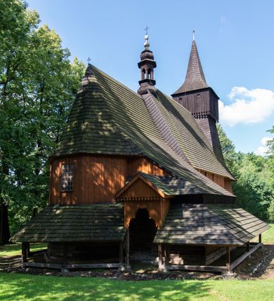 Zdjęcie nr 5: Kościół jest usytuowany ustronnie na stoku wzniesienia, otoczony starodrzewiem i parkanem, ujmującym stary cmentarz z nielicznymi mogiłami i nagrobkami. Orientowaną świątynię w całości wzniesiono z drewna. Zastosowano konstrukcję zrębową na murowanej podwalinie z murowaną kryptą pod prezbiterium. Nawa kościoła jest prawie kwadratowa. Od wchodu przylega do niej węższe prezbiterium zamknięte trójbocznie. Przy jego północnej ścianie wzniesiono bezokienną zakrystię z wejściem od strony wschodniej. Od zachodu z nawą łączy się wieża na rzucie kwadratu wzniesiona na tzw. słup. Ma pochyłe ściany, szalowane w dolnej części deskami, a w górnej podbite gontem. Wieża zakończona jest nadwieszoną izbicą, zwieńczoną ostrosłupowym hełmem gontowym. W połowie wysokości wieżę opasa pulpitowy daszek gontowy łączący się po bokach z dachem nawy. Pod wieżą urządzono obszerną kruchtę. Wysokie i spadziste dachy kościoła pokryte są gontem. Więźba ma konstrukcję storczykową. Ponad wschodnim szczytem nawy usytuowano nadwieszoną wieżyczkę na sygnaturkę o kształcie cebulastym z latarnią zwieńczoną krzyżem. Całość bryły kościoła (z wyjątkiem wieży) obiegają otwarte soboty, w które przed zakrystią od wschodu wbudowano nowy przedsionek. W nawie od południa znajduje się profilowany portal z nadprożem wykrojonym w ośli grzbiet. Umieszczone w nim drzwi zostały zaopatrzone w stare okucia i antabę. Wnętrze nawy i prezbiterium nakryto płaskimi stropami z pozostałościami późnorenesansowych malowideł z motywem kasetonów z rozetami. Łuk tęczowy jest ostry. Spływa na profilowaną belkę, która jest wsparta na kroksztynach. Na belce tęczowej został ustawiony krucyfiks oraz figury Matki Boskiej i św. Jana Apostoła. Chór muzyczny z dekorowanym malarsko parapetem został wsparty na dwóch słupach. W świątyni znajduje się rokokowy ołtarz główny z obrazem ze sceną Zwiastowania NMP. Dwa ołtarze boczne ustawione zostały przy łuku tęczowym. Prawy ołtarz boczny św. Karola Boromeusza pochodzi z drugiej połowy XVII wieku. Na to miejsce trafił on w połowie XX wieku z kaplicy pałacu w Osieku. Lewy ołtarz boczny jest późnobarokowy z około 1700 roku. W jego centrum umieszczono obraz Matki Boskiej Piekarskiej. Na północnej ścianie nad wejściem do zakrystii zawieszono epitafium Mikołaja i Beaty z Mirowa Porębskich z 1611 roku. Wcześniej epitafium pełniło rolę retabulum w miejscu stojącego dziś ołtarza św. Karola Boromeusza. W prezbiterium przy łuku tęczowym zawieszono rokokową ambonę w kształcie łodzi, na którą wejście prowadzi z zakrystii. Przy wejściu do nawy znajduje się kamienna chrzcielnica z początku XVI wieku, ozdobiona herbem Fogelweder, z drewnianą, późnobarokową nakrywą. W zakrystii zachował się także rokokowy drewniany lawetarz z drugiej połowy XVIII wieku.     