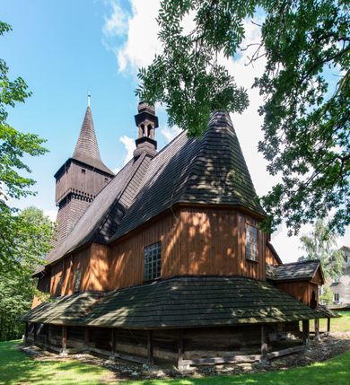 Zdjęcie nr 3: Kościół jest usytuowany ustronnie na stoku wzniesienia, otoczony starodrzewiem i parkanem, ujmującym stary cmentarz z nielicznymi mogiłami i nagrobkami. Orientowaną świątynię w całości wzniesiono z drewna. Zastosowano konstrukcję zrębową na murowanej podwalinie z murowaną kryptą pod prezbiterium. Nawa kościoła jest prawie kwadratowa. Od wchodu przylega do niej węższe prezbiterium zamknięte trójbocznie. Przy jego północnej ścianie wzniesiono bezokienną zakrystię z wejściem od strony wschodniej. Od zachodu z nawą łączy się wieża na rzucie kwadratu wzniesiona na tzw. słup. Ma pochyłe ściany, szalowane w dolnej części deskami, a w górnej podbite gontem. Wieża zakończona jest nadwieszoną izbicą, zwieńczoną ostrosłupowym hełmem gontowym. W połowie wysokości wieżę opasa pulpitowy daszek gontowy łączący się po bokach z dachem nawy. Pod wieżą urządzono obszerną kruchtę. Wysokie i spadziste dachy kościoła pokryte są gontem. Więźba ma konstrukcję storczykową. Ponad wschodnim szczytem nawy usytuowano nadwieszoną wieżyczkę na sygnaturkę o kształcie cebulastym z latarnią zwieńczoną krzyżem. Całość bryły kościoła (z wyjątkiem wieży) obiegają otwarte soboty, w które przed zakrystią od wschodu wbudowano nowy przedsionek. W nawie od południa znajduje się profilowany portal z nadprożem wykrojonym w ośli grzbiet. Umieszczone w nim drzwi zostały zaopatrzone w stare okucia i antabę. Wnętrze nawy i prezbiterium nakryto płaskimi stropami z pozostałościami późnorenesansowych malowideł z motywem kasetonów z rozetami. Łuk tęczowy jest ostry. Spływa na profilowaną belkę, która jest wsparta na kroksztynach. Na belce tęczowej został ustawiony krucyfiks oraz figury Matki Boskiej i św. Jana Apostoła. Chór muzyczny z dekorowanym malarsko parapetem został wsparty na dwóch słupach. W świątyni znajduje się rokokowy ołtarz główny z obrazem ze sceną Zwiastowania NMP. Dwa ołtarze boczne ustawione zostały przy łuku tęczowym. Prawy ołtarz boczny św. Karola Boromeusza pochodzi z drugiej połowy XVII wieku. Na to miejsce trafił on w połowie XX wieku z kaplicy pałacu w Osieku. Lewy ołtarz boczny jest późnobarokowy z około 1700 roku. W jego centrum umieszczono obraz Matki Boskiej Piekarskiej. Na północnej ścianie nad wejściem do zakrystii zawieszono epitafium Mikołaja i Beaty z Mirowa Porębskich z 1611 roku. Wcześniej epitafium pełniło rolę retabulum w miejscu stojącego dziś ołtarza św. Karola Boromeusza. W prezbiterium przy łuku tęczowym zawieszono rokokową ambonę w kształcie łodzi, na którą wejście prowadzi z zakrystii. Przy wejściu do nawy znajduje się kamienna chrzcielnica z początku XVI wieku, ozdobiona herbem Fogelweder, z drewnianą, późnobarokową nakrywą. W zakrystii zachował się także rokokowy drewniany lawetarz z drugiej połowy XVIII wieku.     