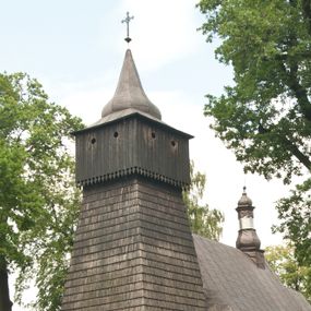 Zdjęcie nr 1: Drewnianą architekturę kościoła charakteryzuje konstrukcja zrębowa. Bryłę świątyni tworzy korpus nawowy oraz węższe, zakończone trójbocznie prezbiterium z przylegającą od północy zakrystią. Od zachodu do korpusu dostawiono wieżę o konstrukcji słupowo-ramowej z izbicą, zwieńczoną cebulastym hełmem przechodzącym w ostrosłup. Ściany pokryte są gontem, izbica wieży pionowym szalunkiem z listwowaniem, dekoracyjnym wycięciem oraz okrągłymi otworami. Korpus nawowy i prezbiterium nakrywają oddzielne, wielopołaciowe dachy o zróżnicowanej wysokości kalenicy, kryte blachą. Wokół bryły kościoła znajdują się otwarte soboty z wydatnymi dachami gontowymi. 
Wnętrze świątyni przekrywają płaskie stropy wydzielone profilowanym gzymsem. Otwory drzwiowe ujęte są późnogotyckimi portalami o nadprożach w formie tzw. łuku w ośli grzbiet. Profilowany łuk tęczowy ma kształt półokrągły i jest nadwieszony na kroksztynach. Ściany i stropy pokryte są polichromią.       
