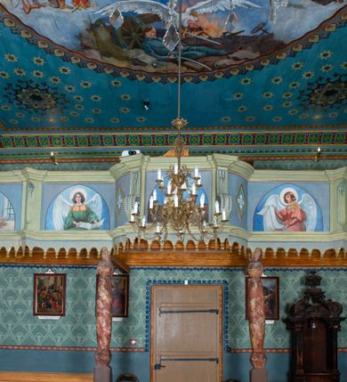 Zdjęcie nr 16: Drewnianą architekturę kościoła charakteryzuje konstrukcja zrębowa. Bryłę świątyni tworzy korpus nawowy oraz węższe, zakończone trójbocznie prezbiterium z przylegającą od północy zakrystią. Od zachodu do korpusu dostawiono wieżę o konstrukcji słupowo-ramowej z izbicą, zwieńczoną cebulastym hełmem przechodzącym w ostrosłup. Ściany pokryte są gontem, izbica wieży pionowym szalunkiem z listwowaniem, dekoracyjnym wycięciem oraz okrągłymi otworami. Korpus nawowy i prezbiterium nakrywają oddzielne, wielopołaciowe dachy o zróżnicowanej wysokości kalenicy, kryte blachą. Wokół bryły kościoła znajdują się otwarte soboty z wydatnymi dachami gontowymi. 
Wnętrze świątyni przekrywają płaskie stropy wydzielone profilowanym gzymsem. Otwory drzwiowe ujęte są późnogotyckimi portalami o nadprożach w formie tzw. łuku w ośli grzbiet. Profilowany łuk tęczowy ma kształt półokrągły i jest nadwieszony na kroksztynach. Ściany i stropy pokryte są polichromią.       
