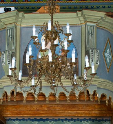 Zdjęcie nr 18: Drewnianą architekturę kościoła charakteryzuje konstrukcja zrębowa. Bryłę świątyni tworzy korpus nawowy oraz węższe, zakończone trójbocznie prezbiterium z przylegającą od północy zakrystią. Od zachodu do korpusu dostawiono wieżę o konstrukcji słupowo-ramowej z izbicą, zwieńczoną cebulastym hełmem przechodzącym w ostrosłup. Ściany pokryte są gontem, izbica wieży pionowym szalunkiem z listwowaniem, dekoracyjnym wycięciem oraz okrągłymi otworami. Korpus nawowy i prezbiterium nakrywają oddzielne, wielopołaciowe dachy o zróżnicowanej wysokości kalenicy, kryte blachą. Wokół bryły kościoła znajdują się otwarte soboty z wydatnymi dachami gontowymi. 
Wnętrze świątyni przekrywają płaskie stropy wydzielone profilowanym gzymsem. Otwory drzwiowe ujęte są późnogotyckimi portalami o nadprożach w formie tzw. łuku w ośli grzbiet. Profilowany łuk tęczowy ma kształt półokrągły i jest nadwieszony na kroksztynach. Ściany i stropy pokryte są polichromią.       
