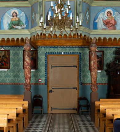 Zdjęcie nr 24: Drewnianą architekturę kościoła charakteryzuje konstrukcja zrębowa. Bryłę świątyni tworzy korpus nawowy oraz węższe, zakończone trójbocznie prezbiterium z przylegającą od północy zakrystią. Od zachodu do korpusu dostawiono wieżę o konstrukcji słupowo-ramowej z izbicą, zwieńczoną cebulastym hełmem przechodzącym w ostrosłup. Ściany pokryte są gontem, izbica wieży pionowym szalunkiem z listwowaniem, dekoracyjnym wycięciem oraz okrągłymi otworami. Korpus nawowy i prezbiterium nakrywają oddzielne, wielopołaciowe dachy o zróżnicowanej wysokości kalenicy, kryte blachą. Wokół bryły kościoła znajdują się otwarte soboty z wydatnymi dachami gontowymi. 
Wnętrze świątyni przekrywają płaskie stropy wydzielone profilowanym gzymsem. Otwory drzwiowe ujęte są późnogotyckimi portalami o nadprożach w formie tzw. łuku w ośli grzbiet. Profilowany łuk tęczowy ma kształt półokrągły i jest nadwieszony na kroksztynach. Ściany i stropy pokryte są polichromią.       
